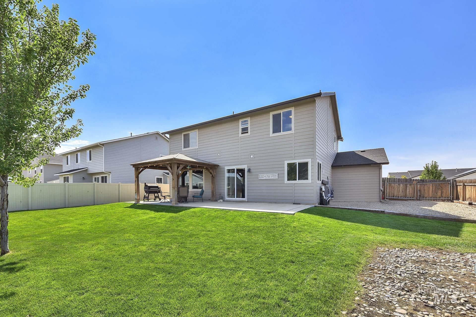 Back of property with a fenced backyard, a patio area, and a gazebo