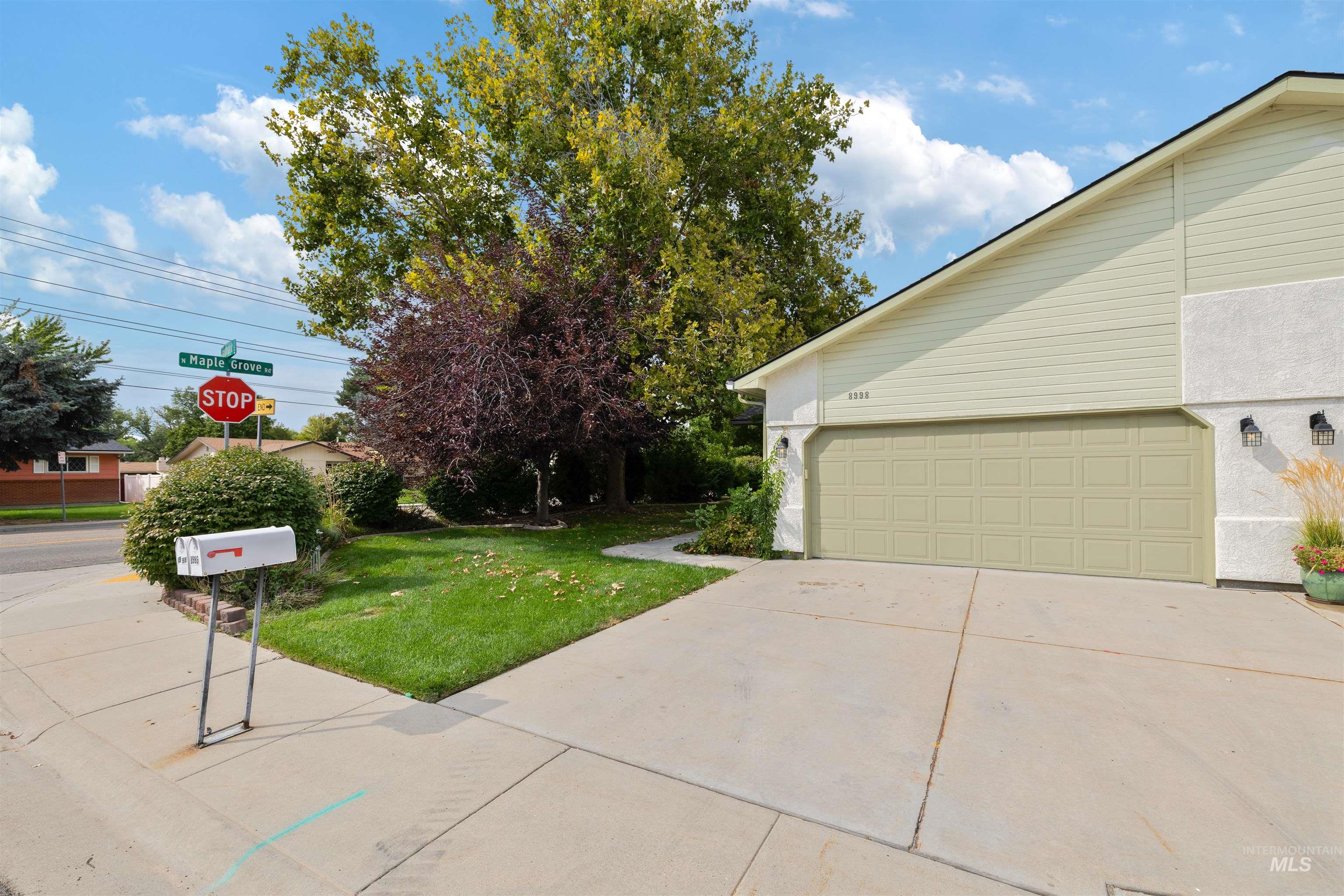 View of home's exterior featuring a garage, concrete driveway, and a lawn