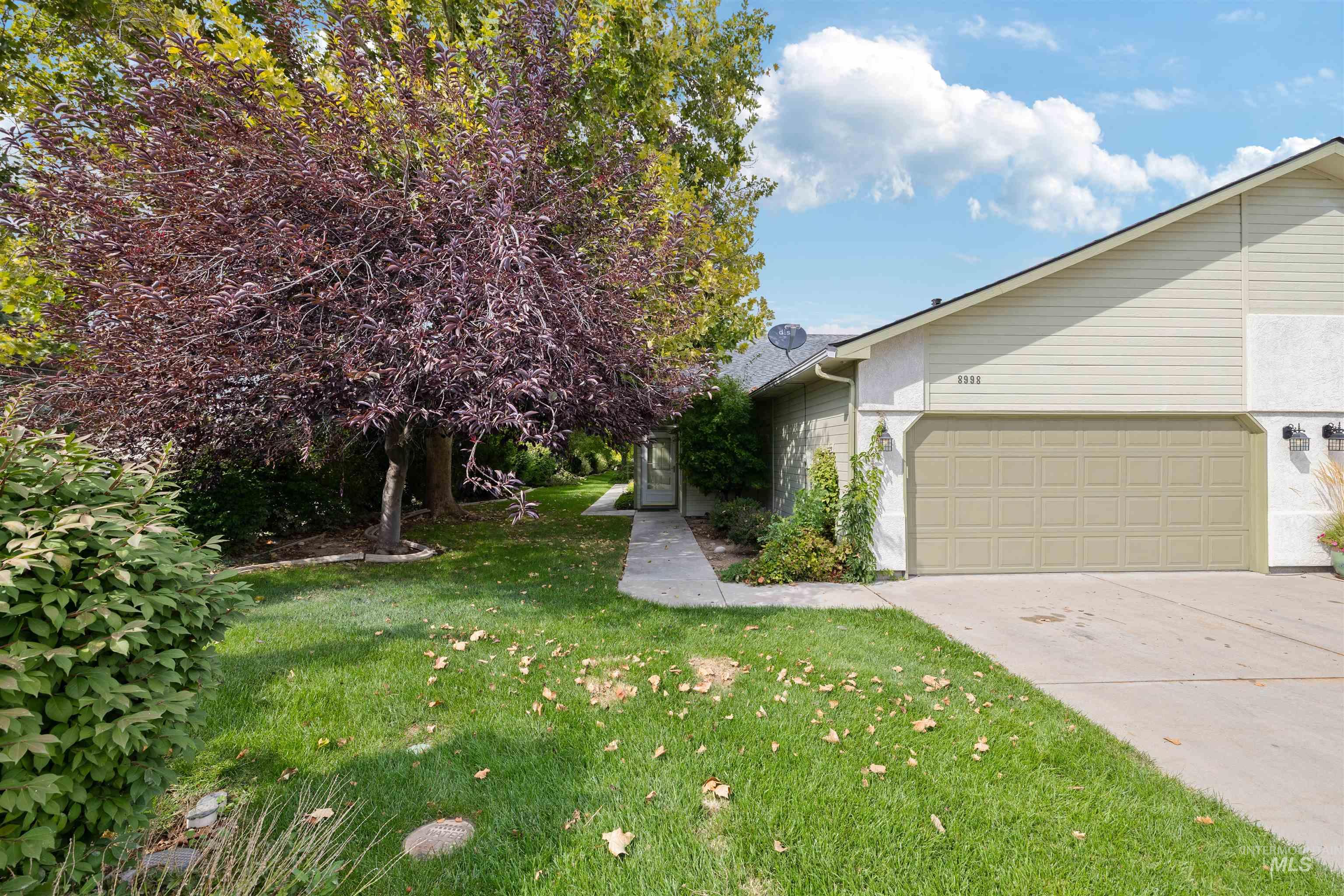 View of side of property with a yard, driveway, and a garage