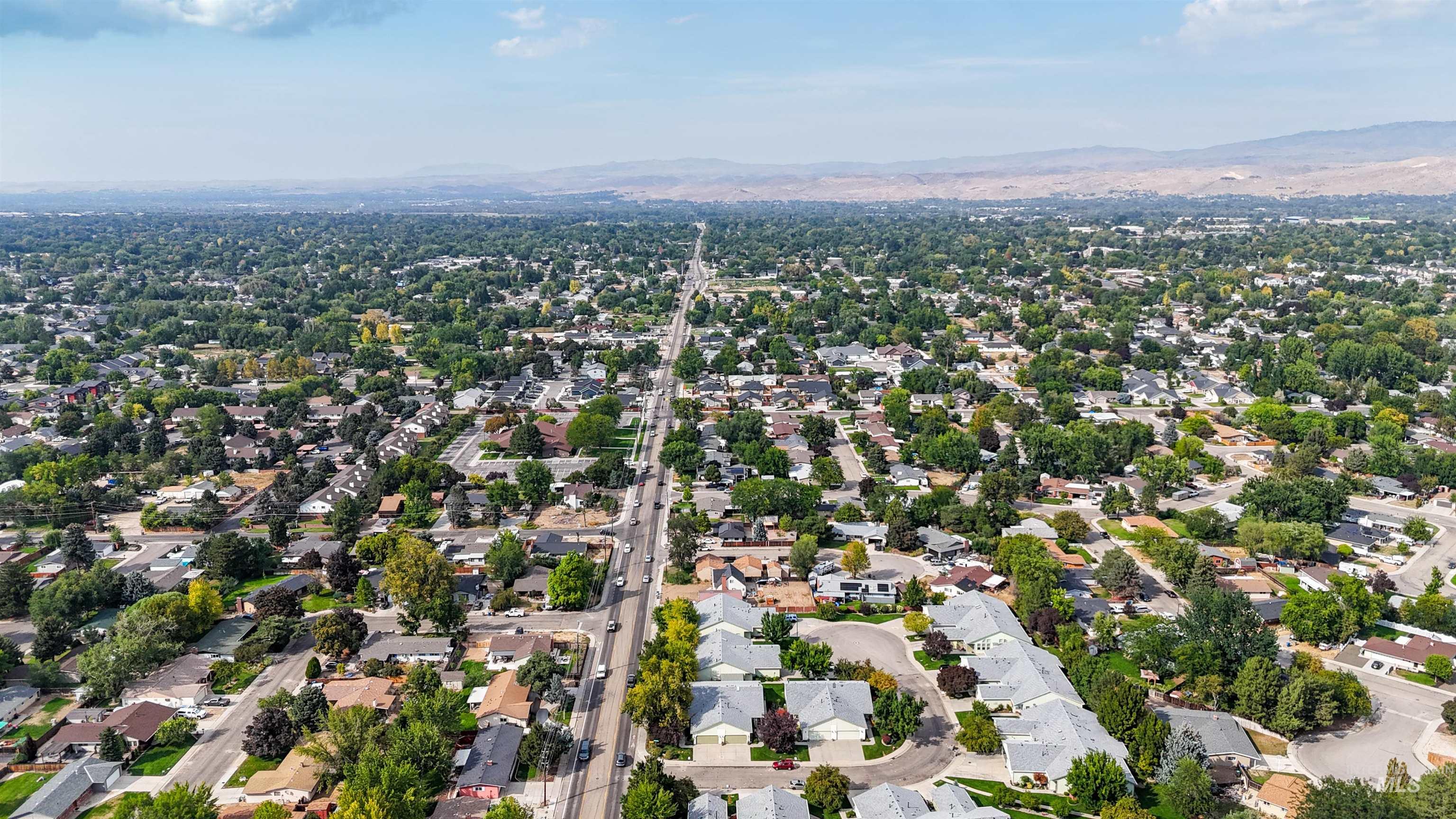 Aerial overview of property's location with nearby suburban area and a mountain backdrop