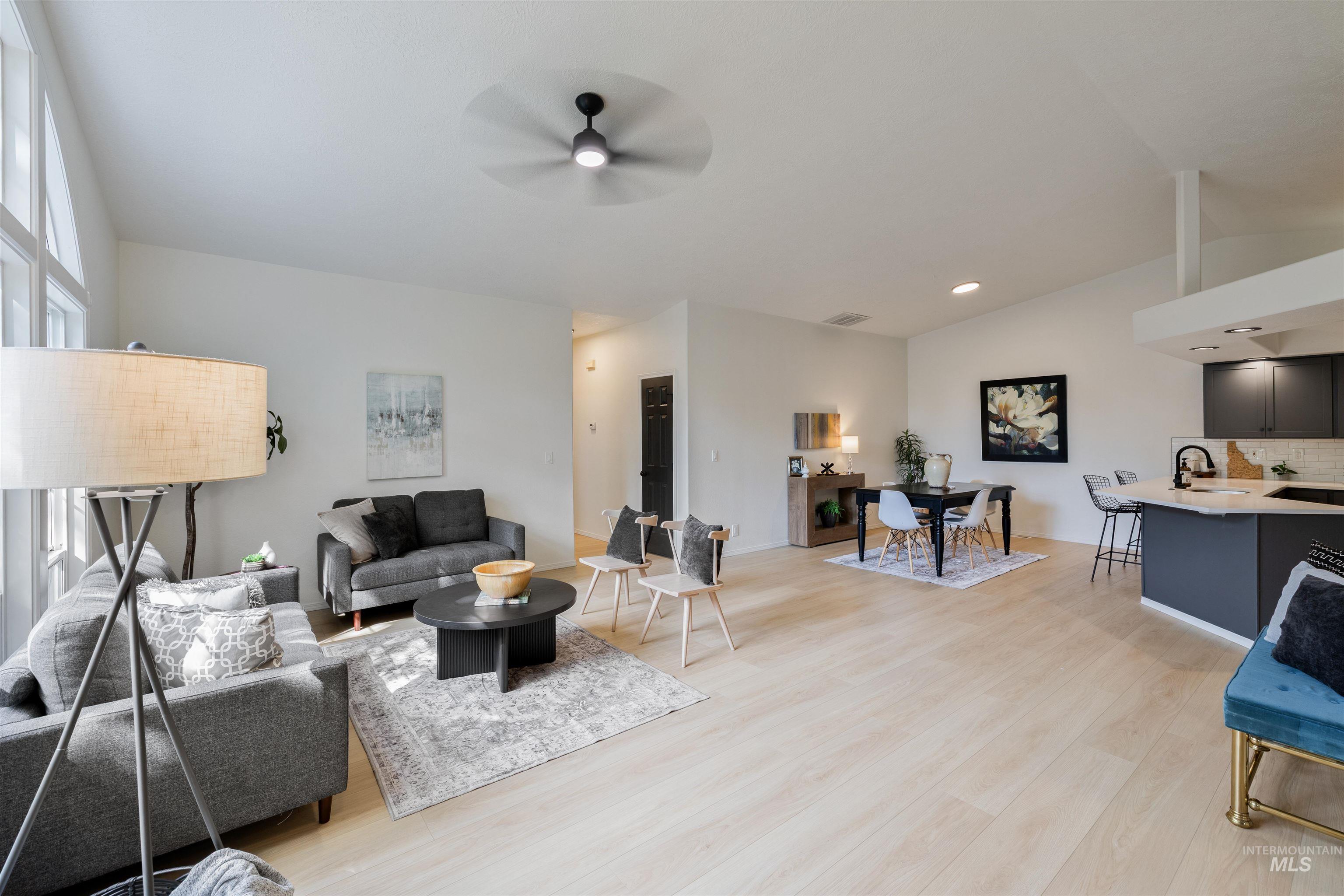Living area featuring light wood finished floors, lofted ceiling, and ceiling fan