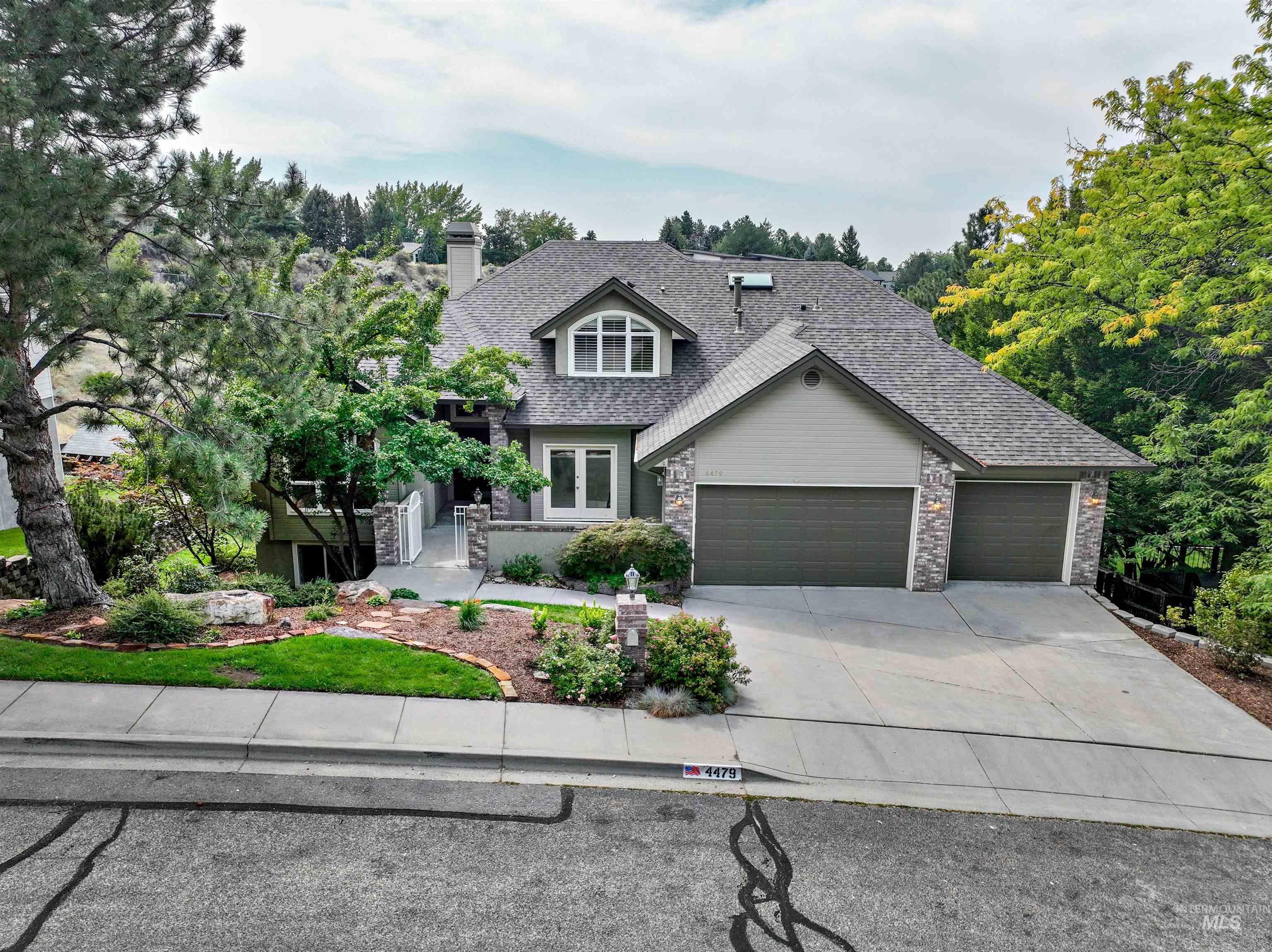 Craftsman house with concrete driveway, stone siding, roof with shingles, and an attached garage