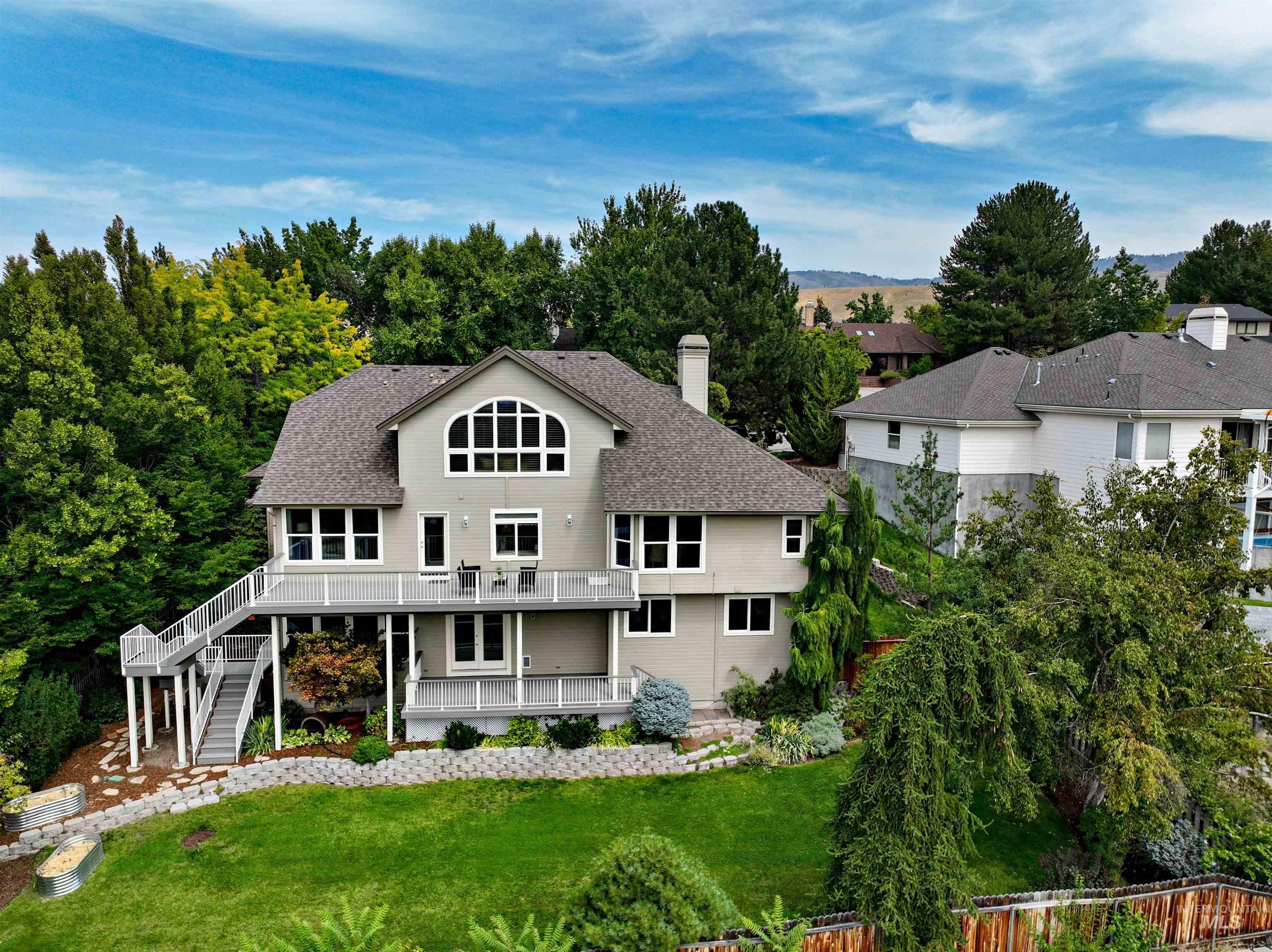 Back of property featuring stairs, a chimney, a deck, and roof with shingles