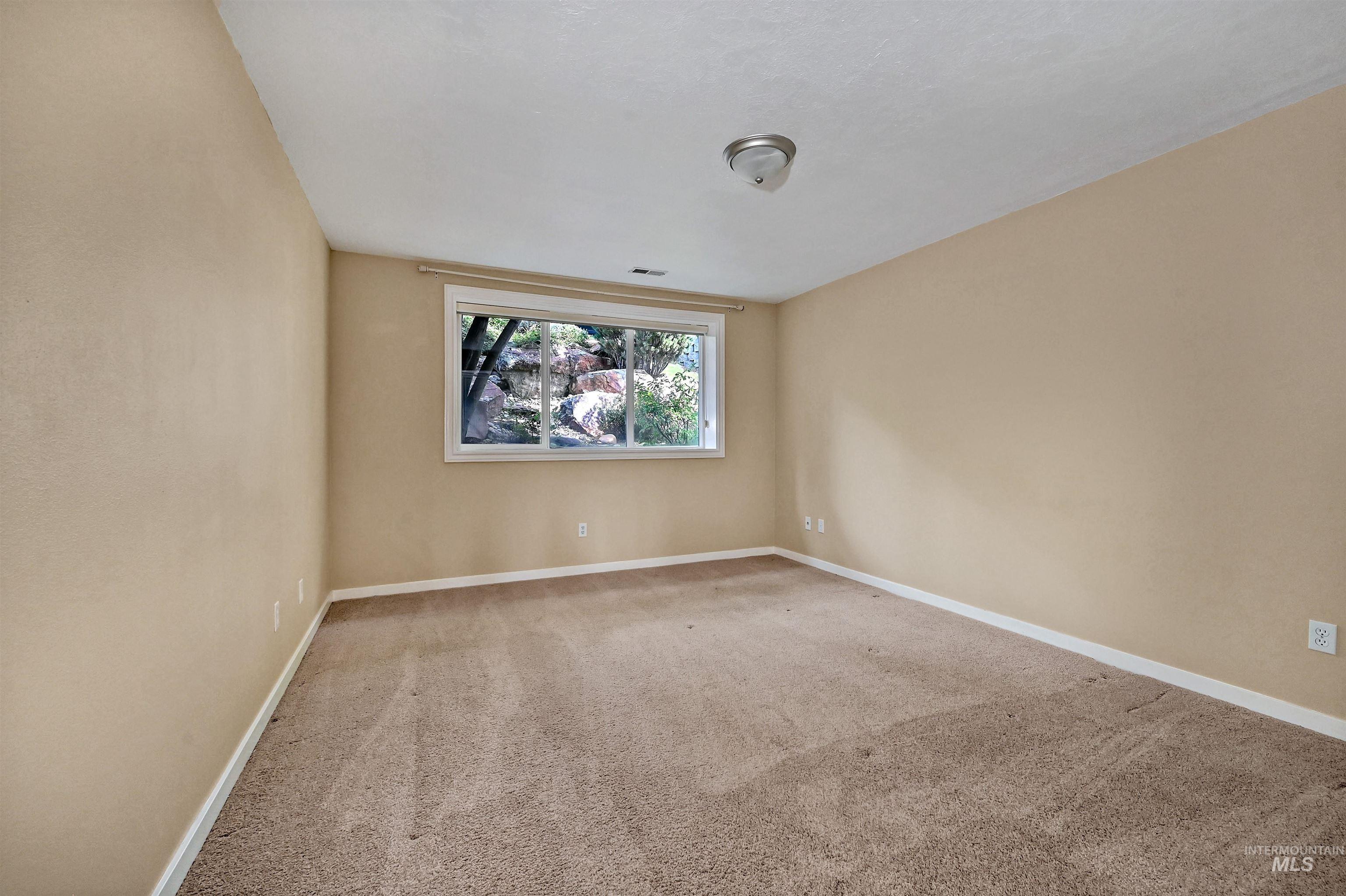 Carpeted empty room featuring baseboards
