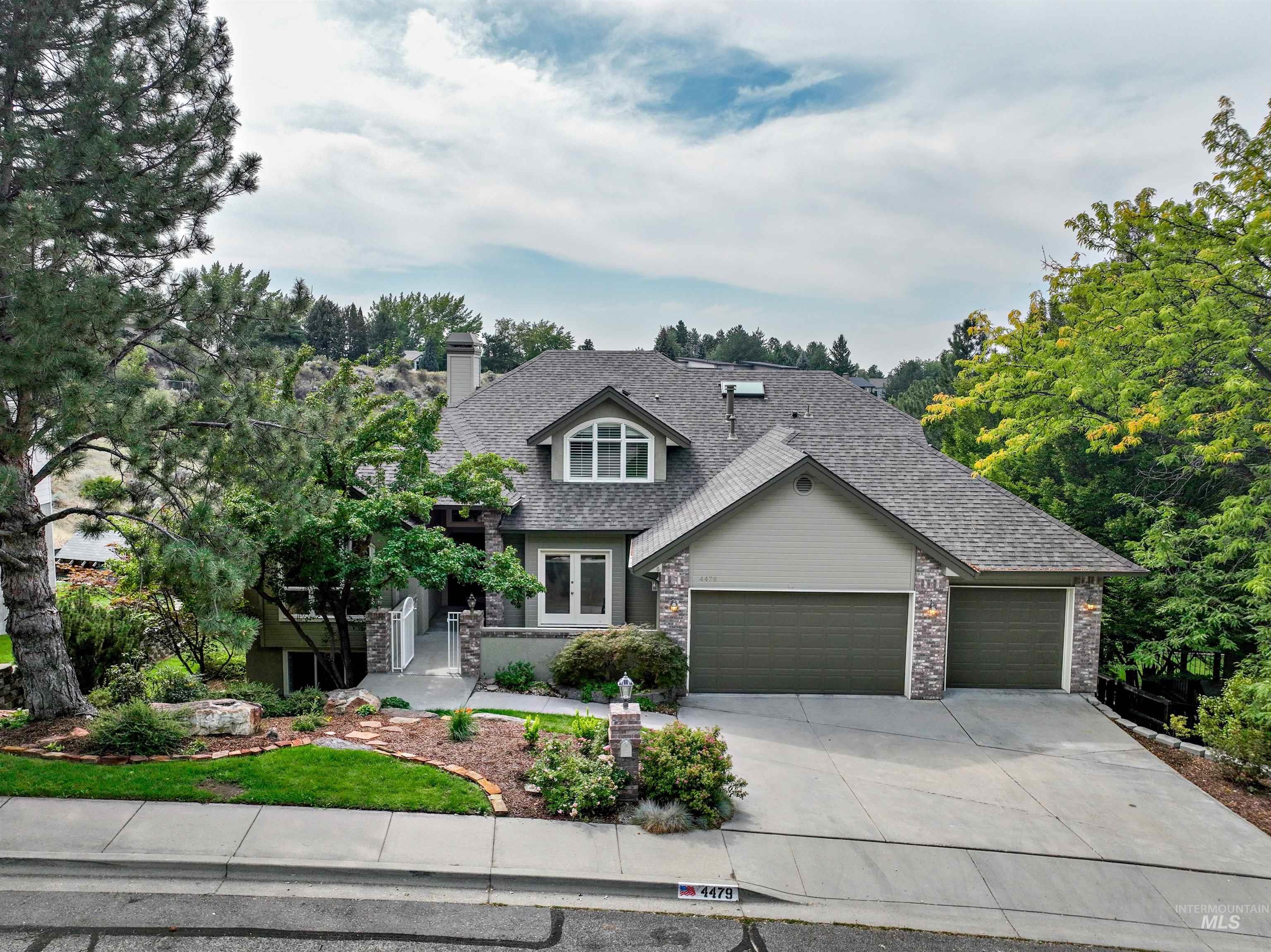Craftsman house featuring concrete driveway, stone siding, a garage, and a shingled roof