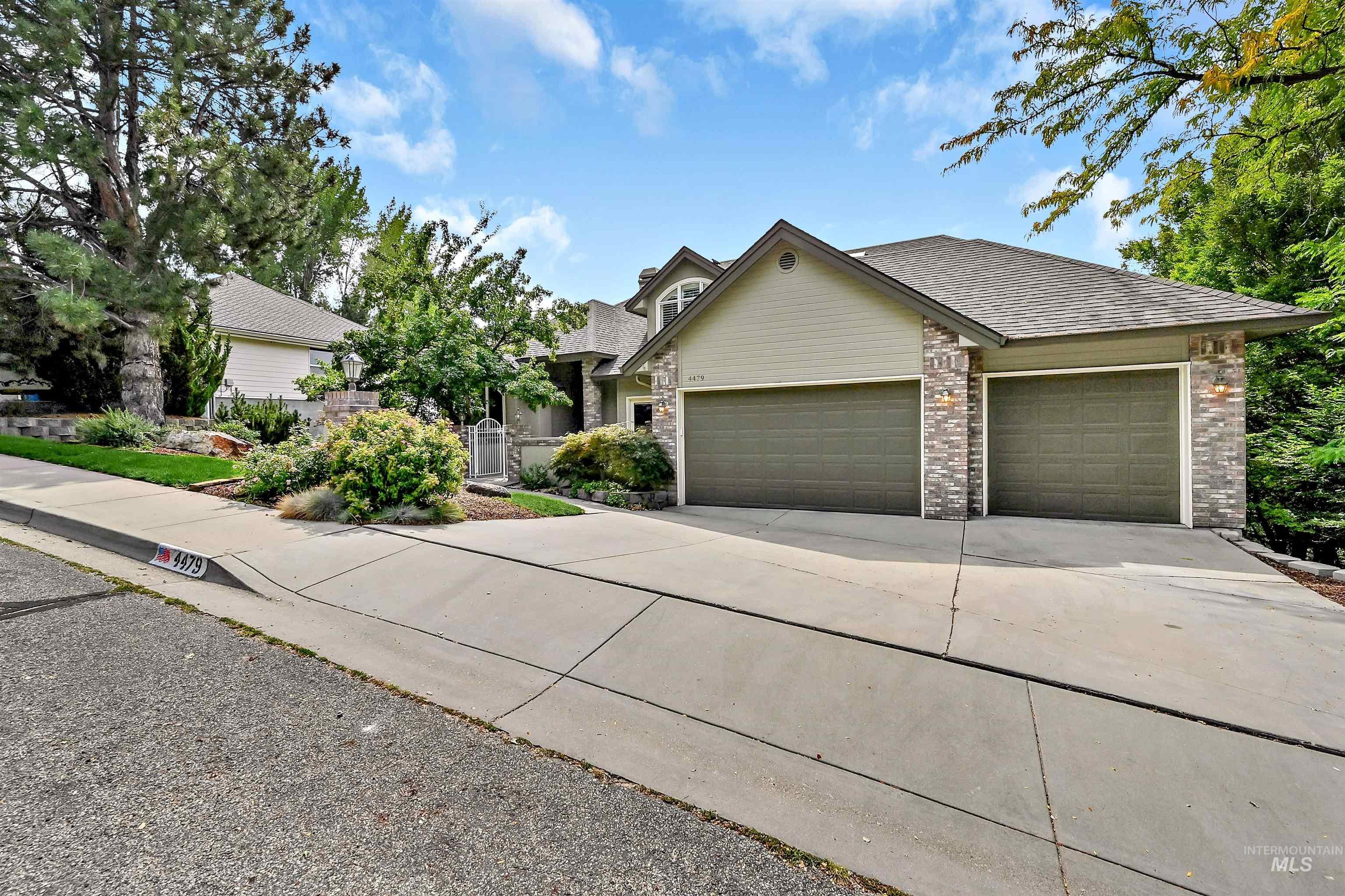 View of front facade featuring concrete driveway, an attached garage, and roof with shingles