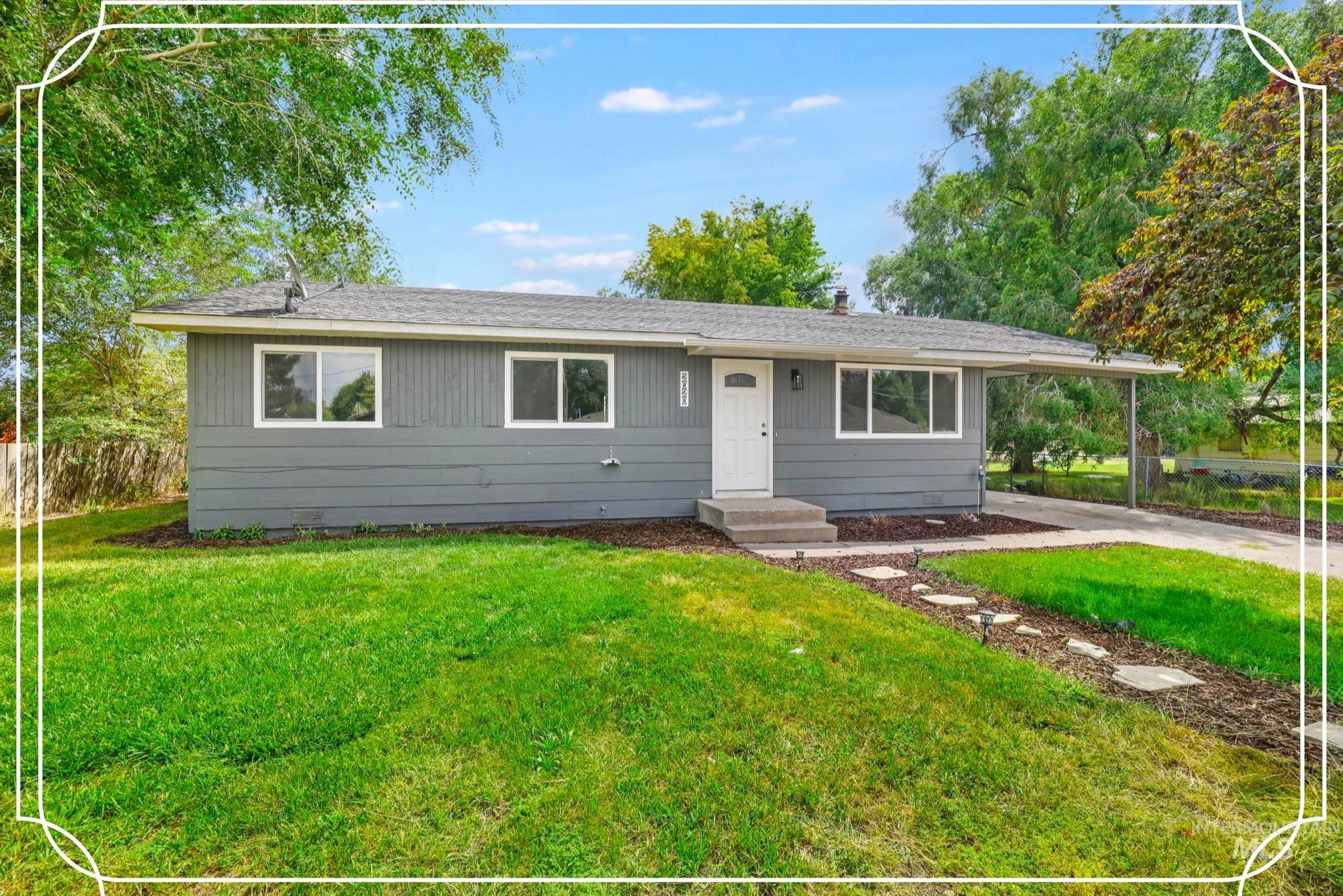 Ranch-style home featuring roof with shingles, an attached carport, a front lawn, and concrete driveway