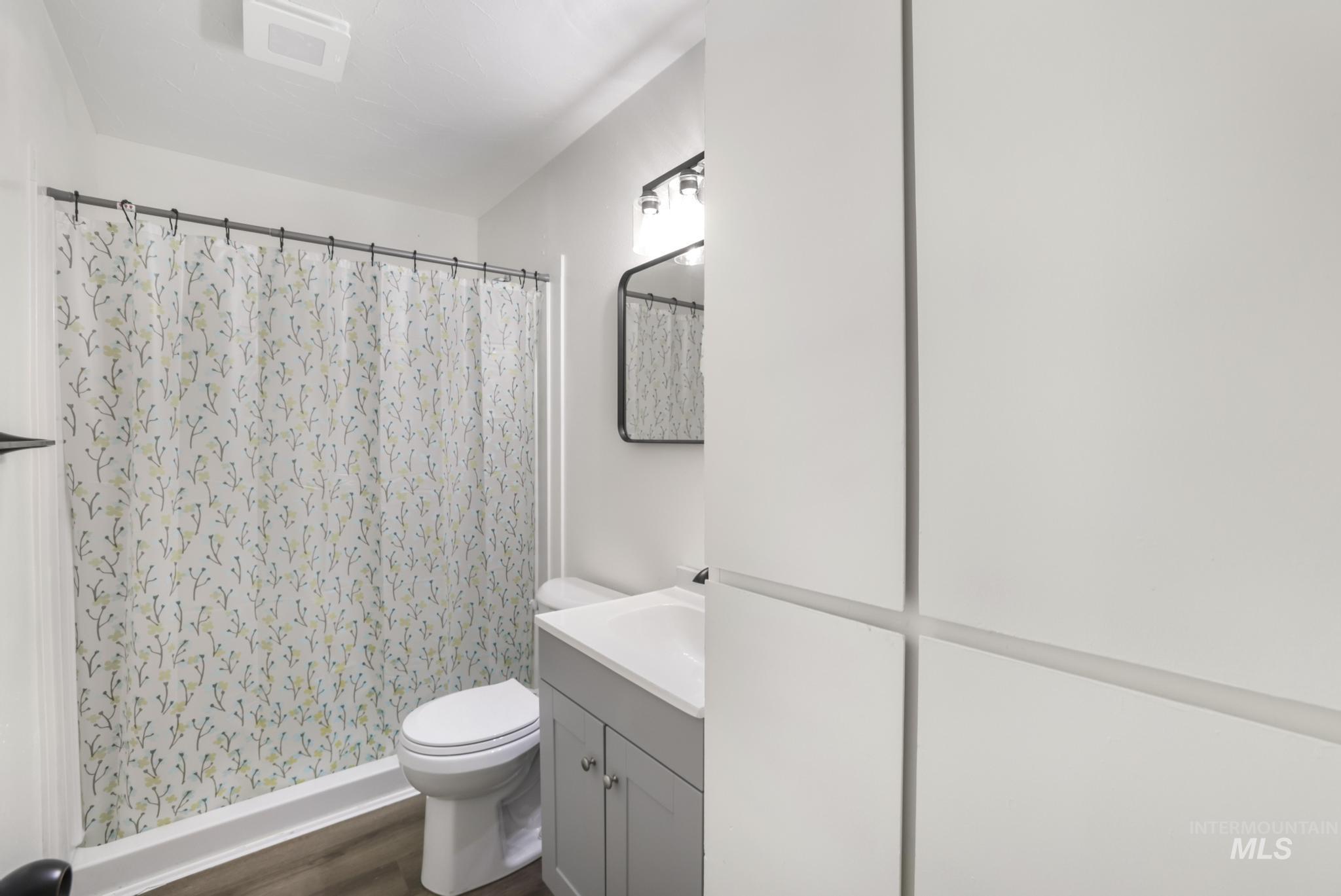 Bathroom with vanity, a shower stall, and dark wood finished floors