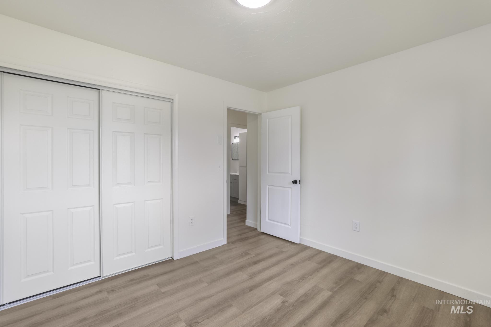 Unfurnished bedroom with wood finished floors and a closet