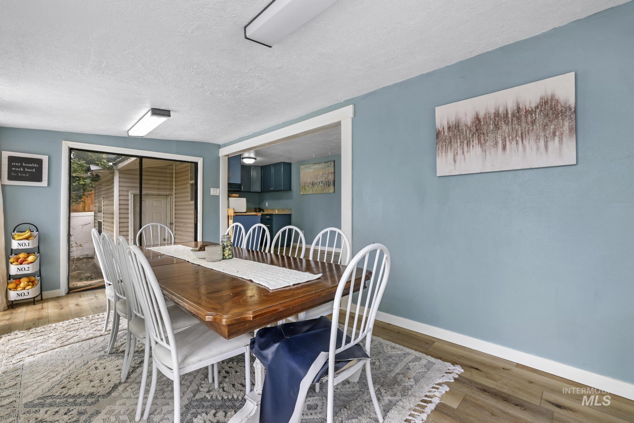 Dining area featuring wood finished floors and a textured ceiling