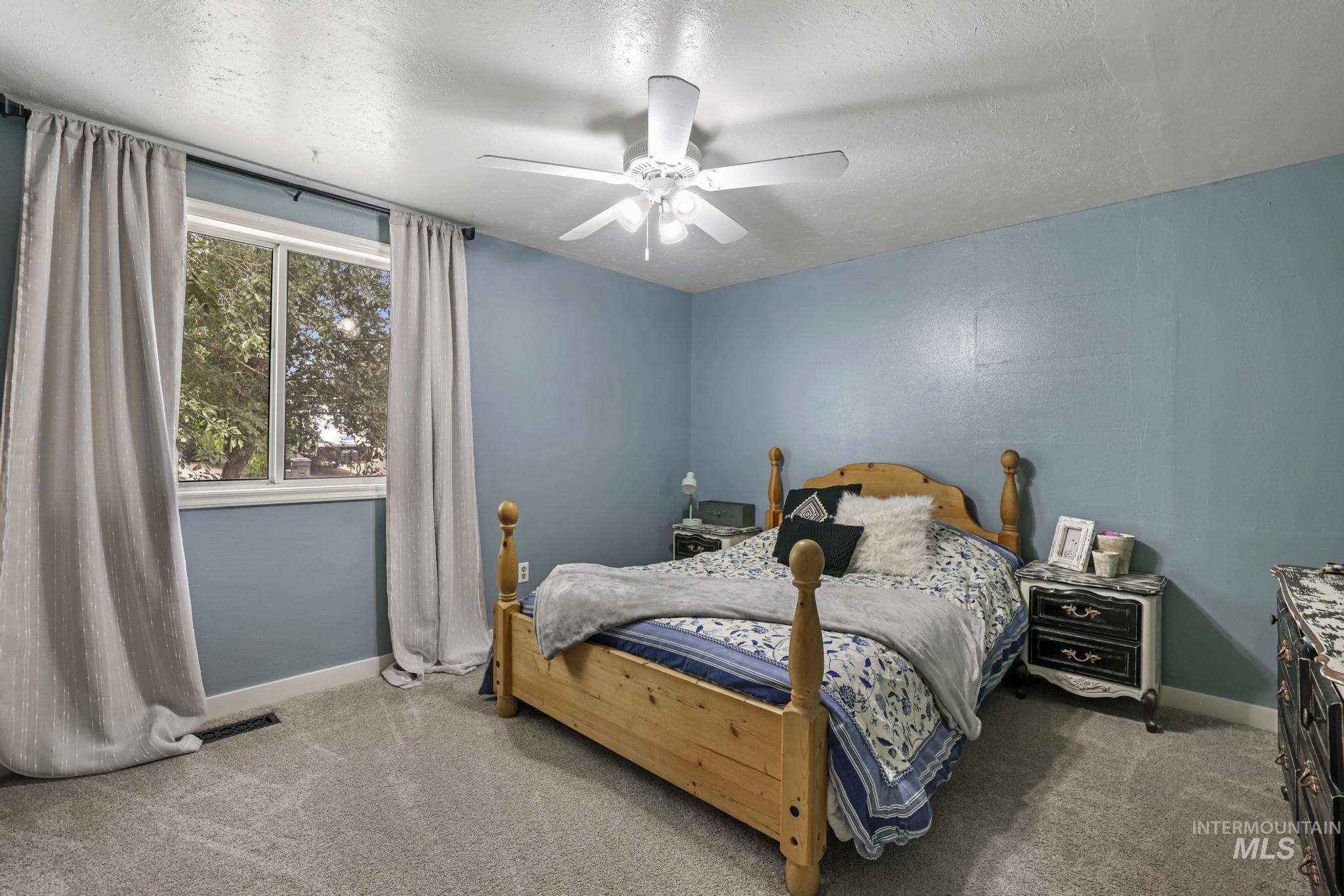 Bedroom featuring carpet floors, a textured ceiling, and a ceiling fan