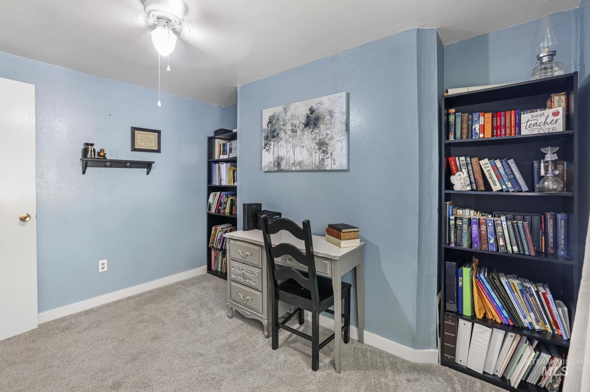 Office area featuring light colored carpet and a ceiling fan