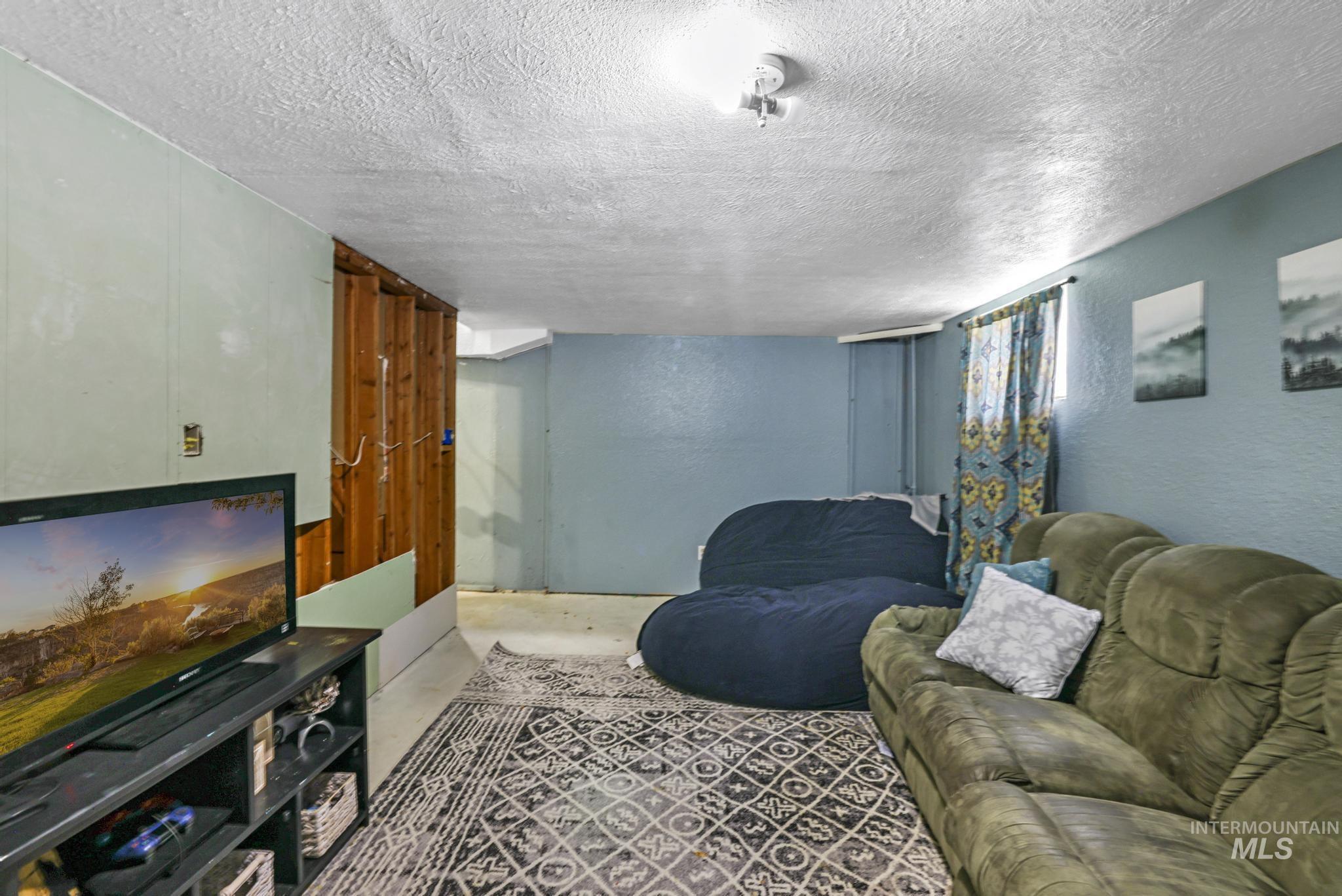 Living room with a textured ceiling and a textured wall