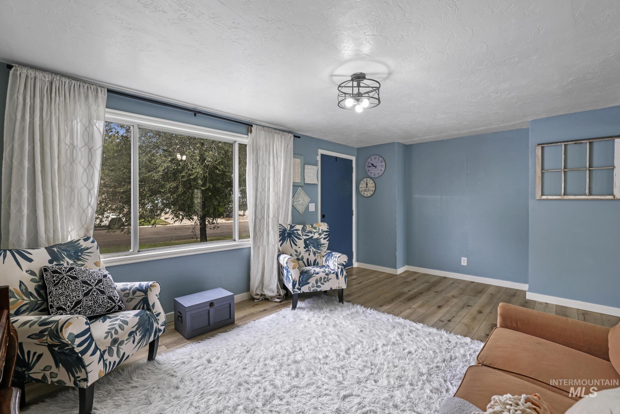 Living room with a textured ceiling and wood finished floors