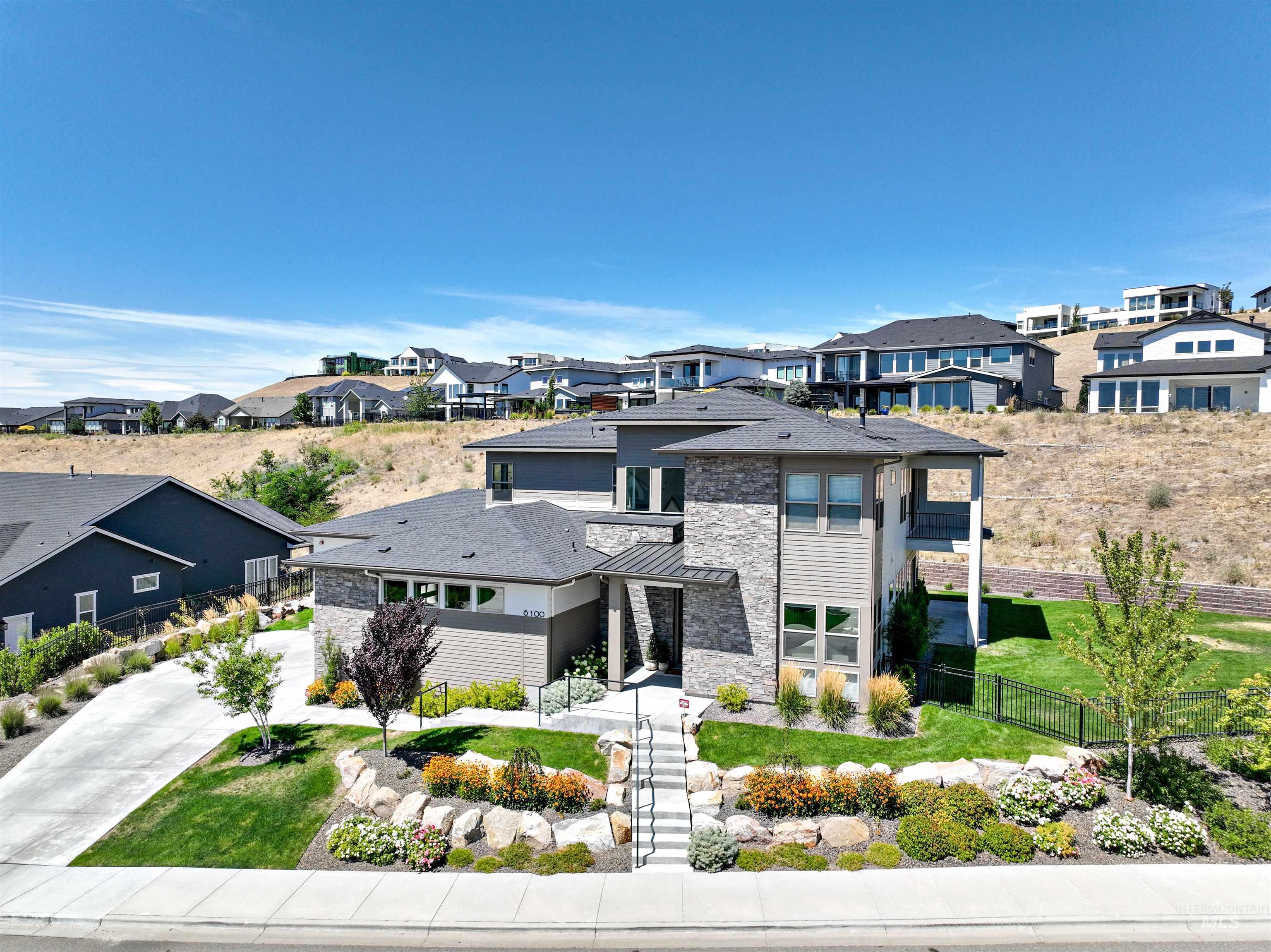 Prairie-style house featuring stone siding, a residential view, and driveway