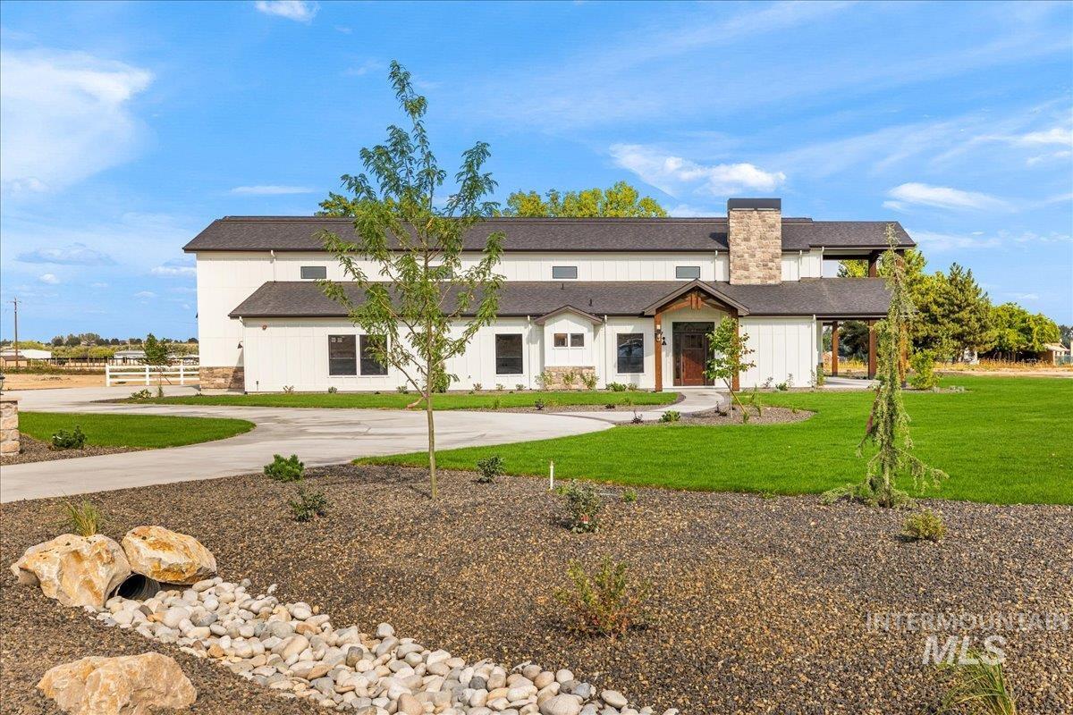 Modern inspired farmhouse with a front yard and a shingled roof