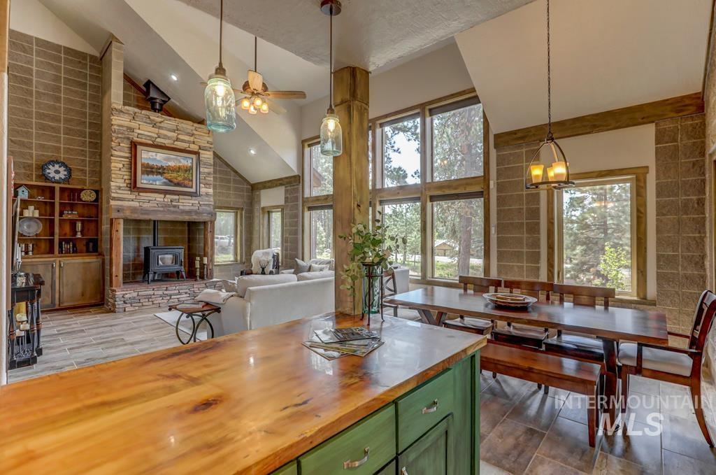 Kitchen featuring green cabinetry, wooden counters, hanging light fixtures, high vaulted ceiling, and ceiling fan