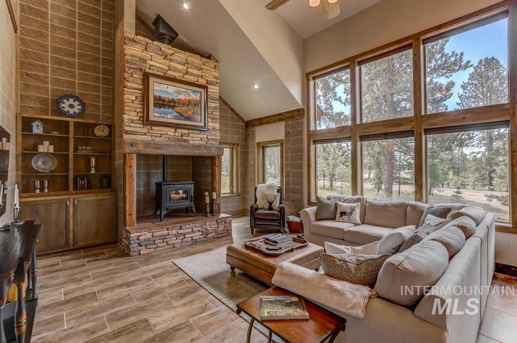 Living area with high vaulted ceiling, a wood stove, recessed lighting, and a ceiling fan