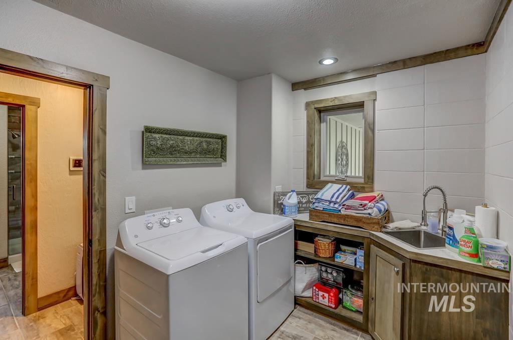 Laundry room featuring a textured ceiling, washing machine and clothes dryer, and cabinet space