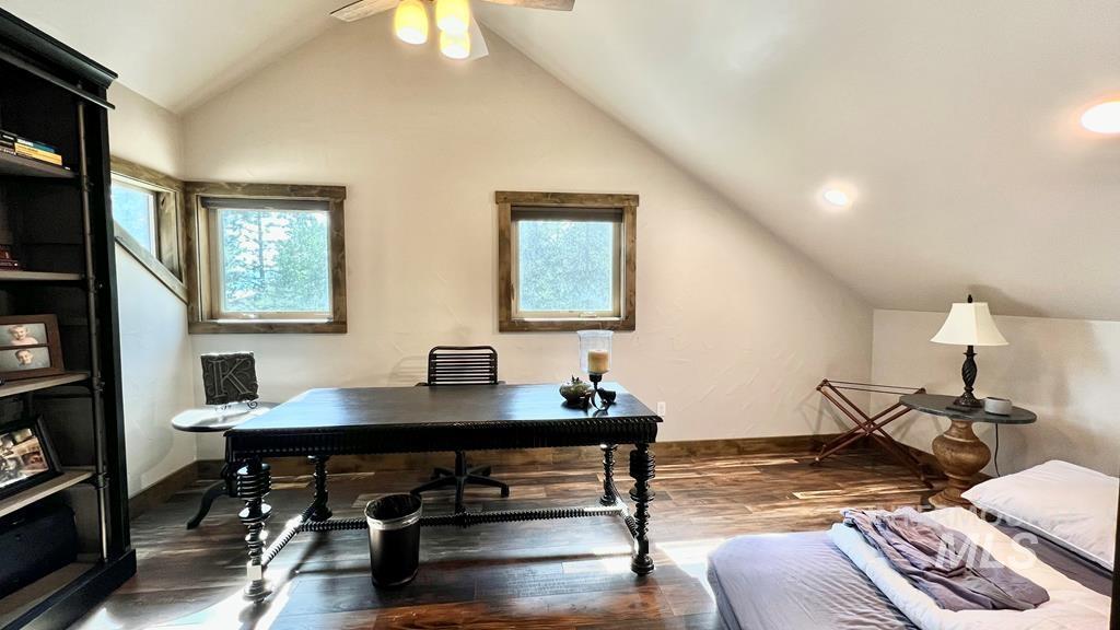 Office area featuring lofted ceiling, wood finished floors, and a ceiling fan