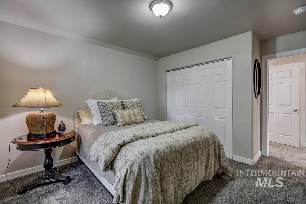 Carpeted bedroom with a closet and baseboards