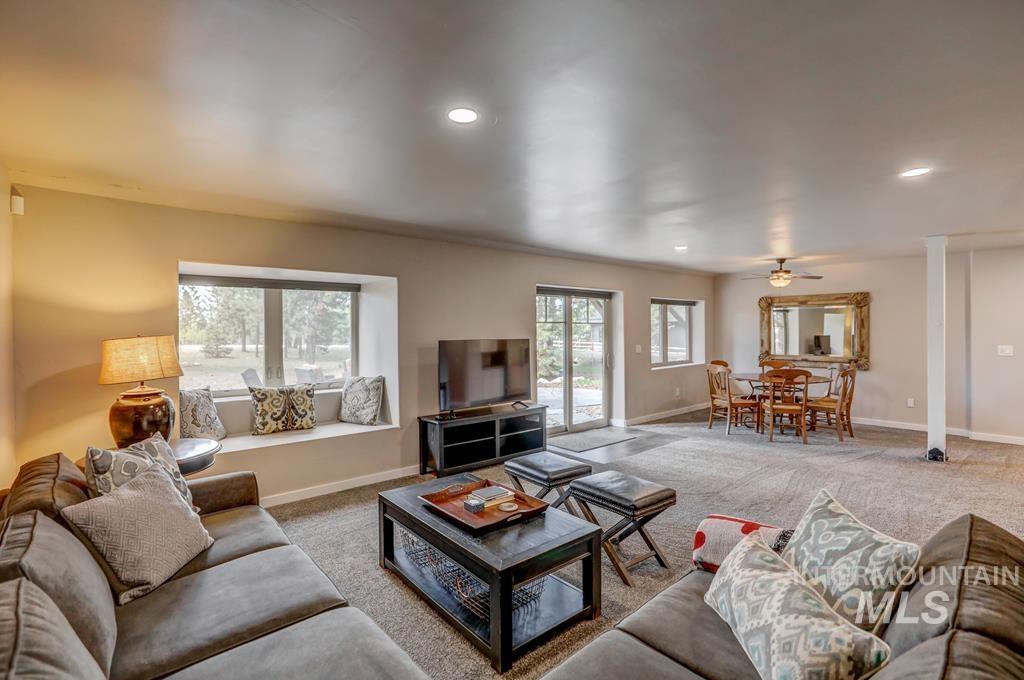 Carpeted living area featuring plenty of natural light, recessed lighting, and a ceiling fan