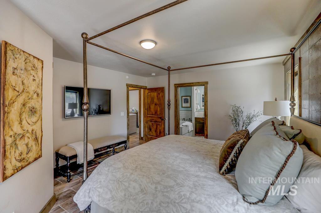 Bedroom featuring wood finished floors and connected bathroom