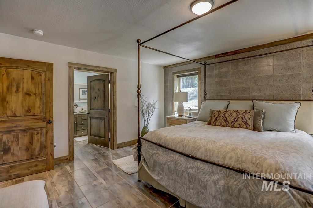 Bedroom with ensuite bathroom and a textured ceiling