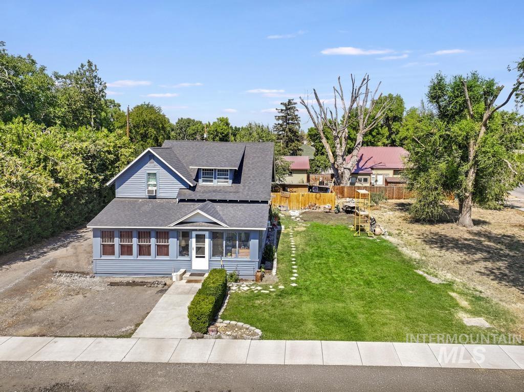 View of front of house with a shingled roof, a sunroom, and driveway