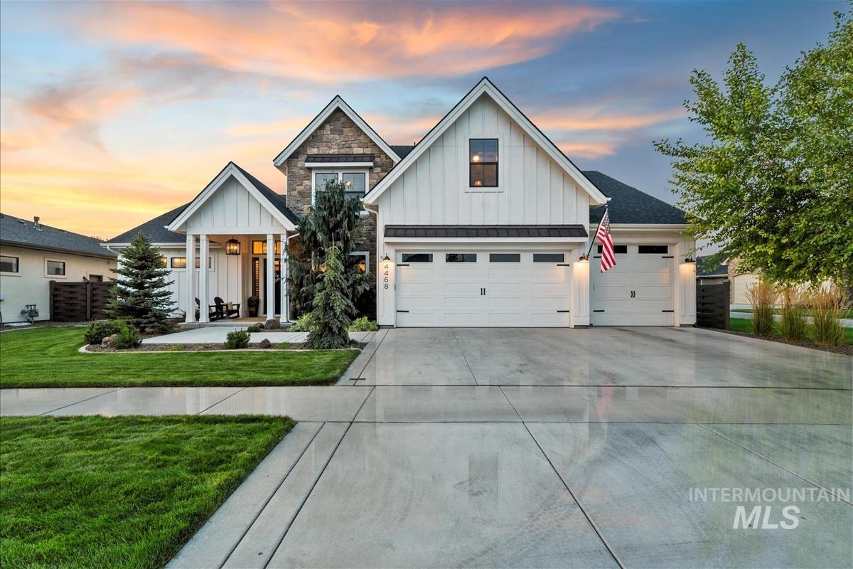Modern inspired farmhouse featuring board and batten siding, a standing seam roof, concrete driveway, a metal roof, and a yard
