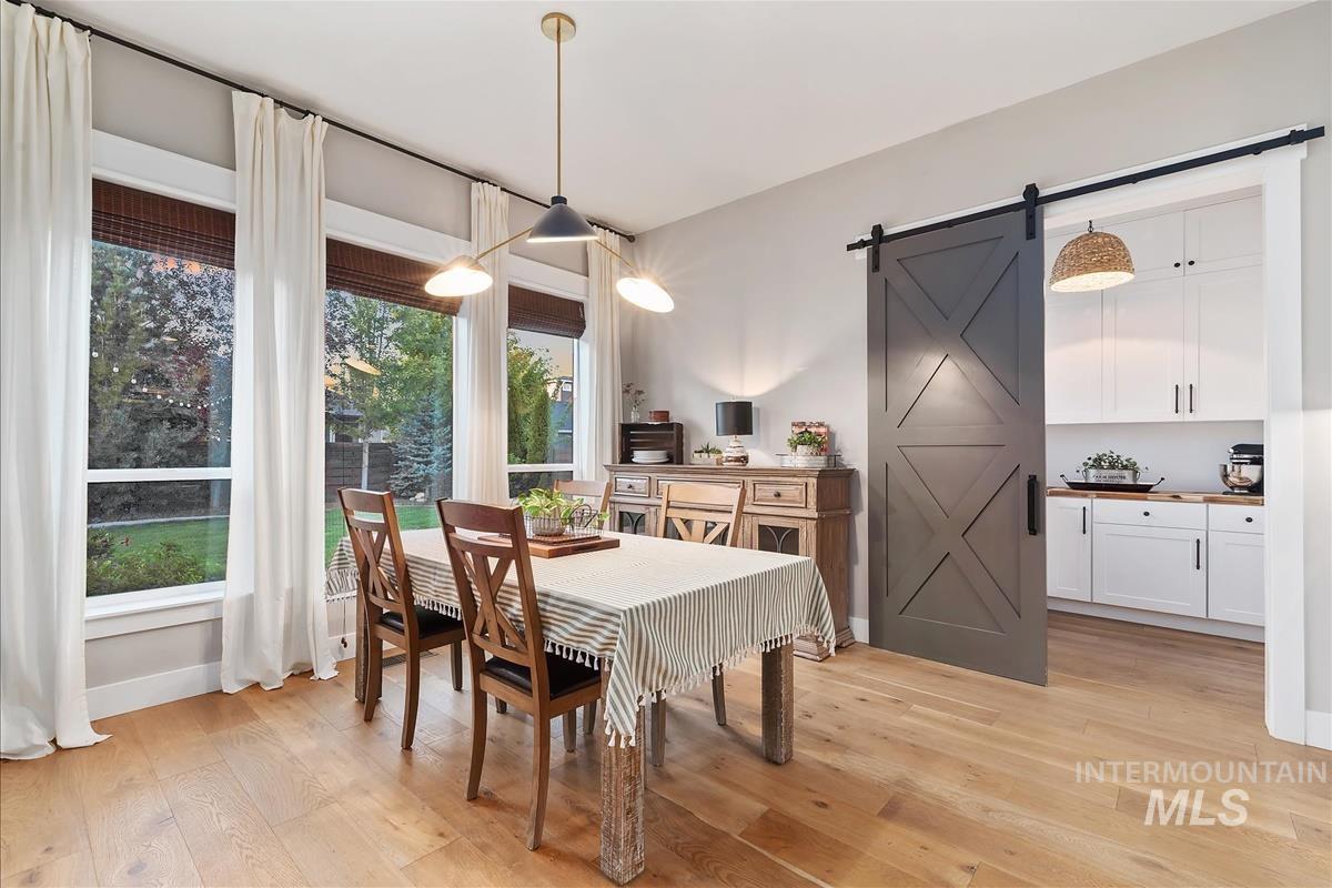 Dining room featuring a barn door and light wood-type flooring