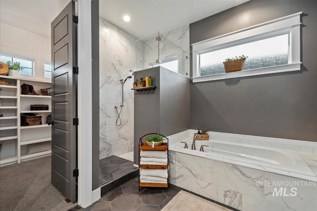 Full bath featuring a bath, a marble finish shower, a walk in closet, and recessed lighting