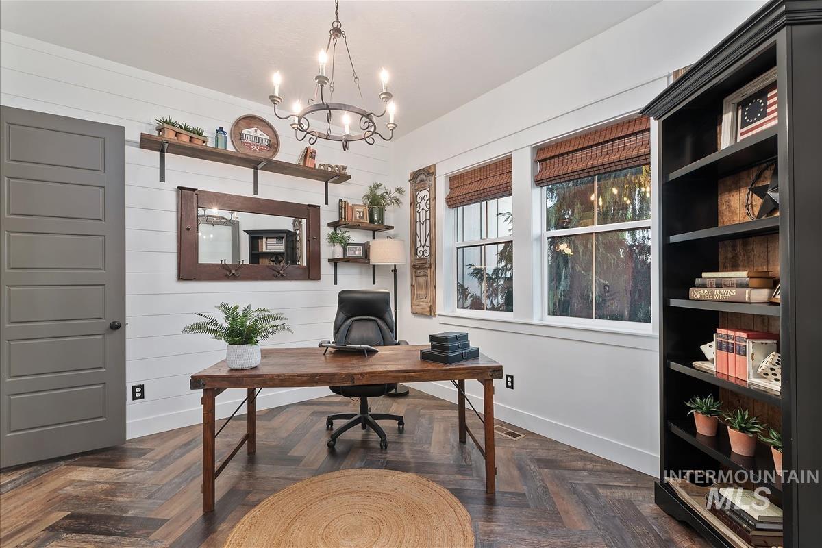 Office area with a chandelier and wood walls