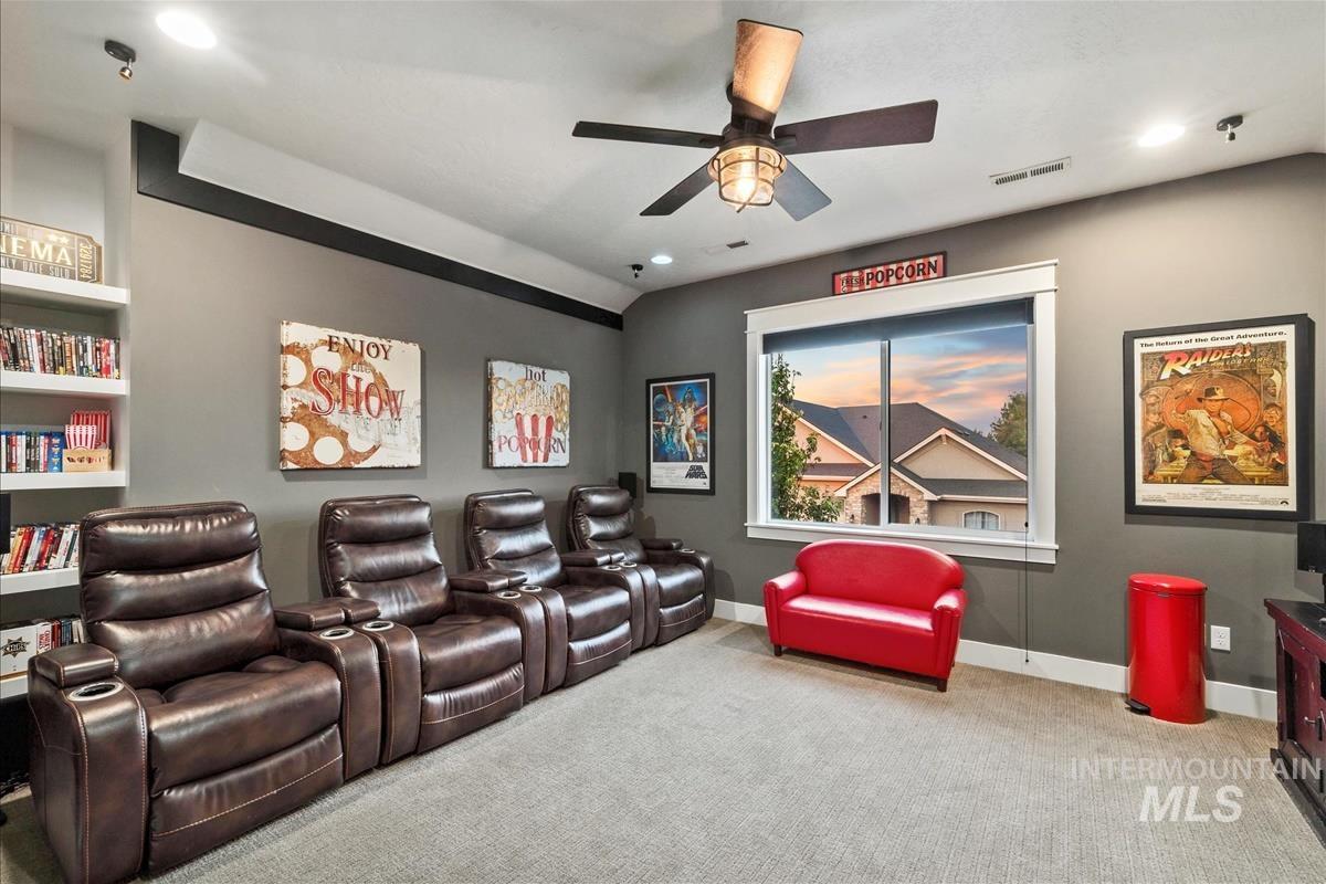 Carpeted cinema room with recessed lighting and a ceiling fan