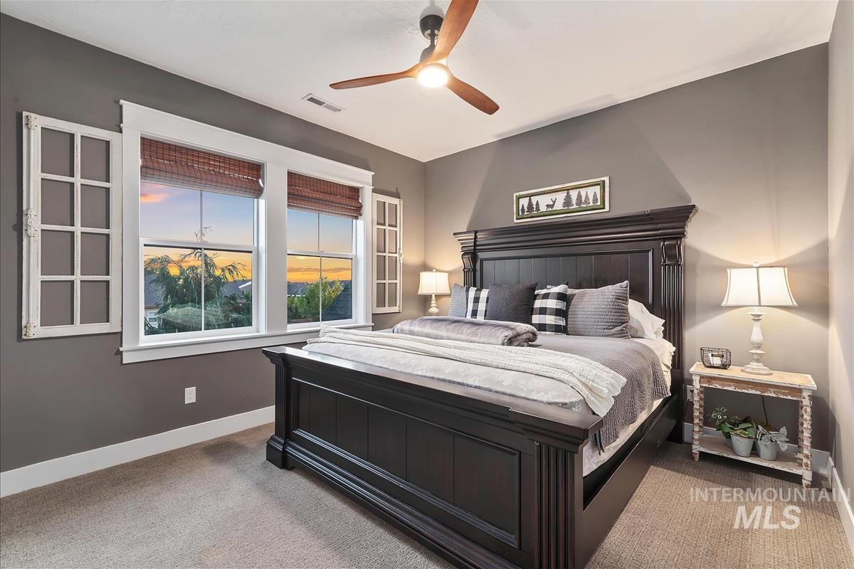 Carpeted bedroom with baseboards and a ceiling fan