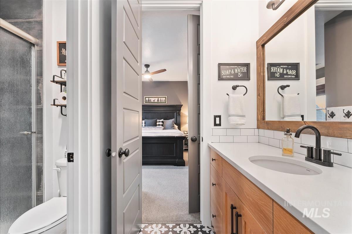 Bathroom with a shower stall, vanity, ensuite bathroom, and a ceiling fan