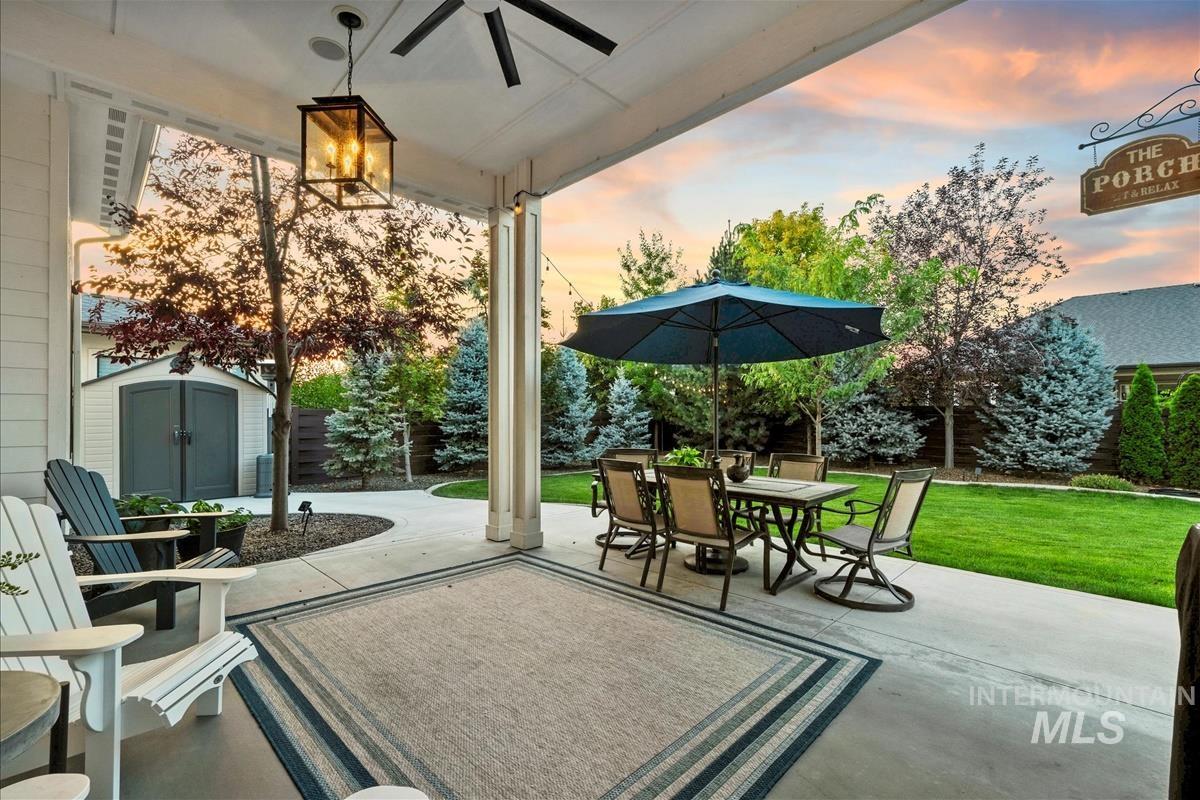 Fenced backyard featuring a patio area, outdoor dining area, and a shed