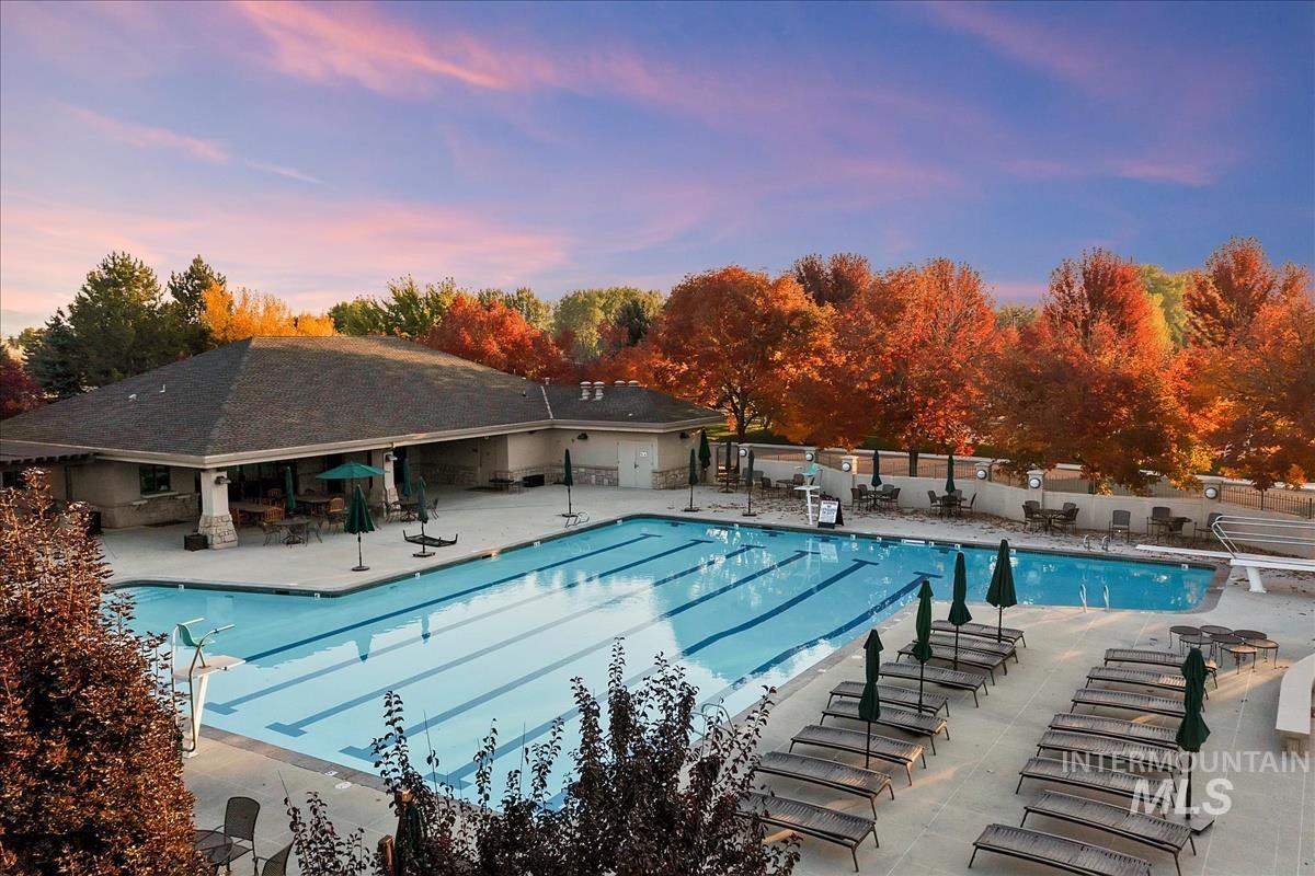 Pool at dusk with a patio and a community pool
