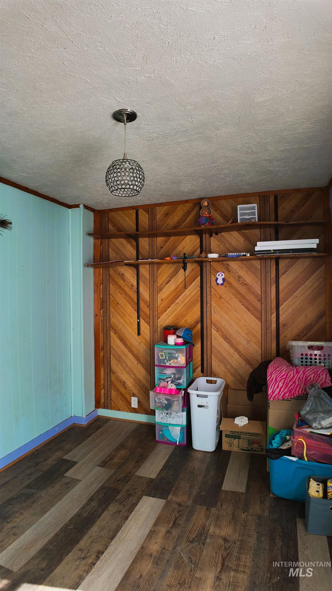Detailed view of wooden walls, wood finished floors, and a textured ceiling