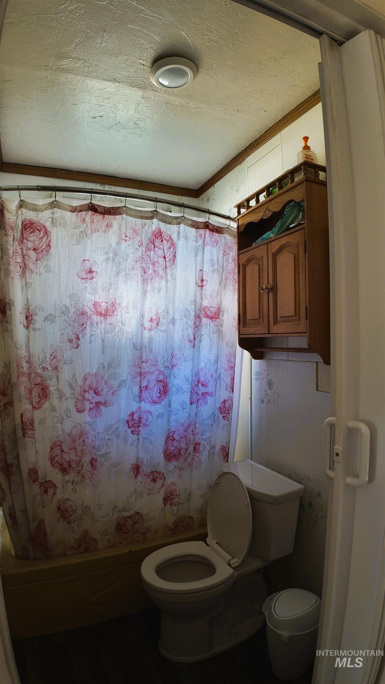 Bathroom featuring a textured ceiling and toilet
