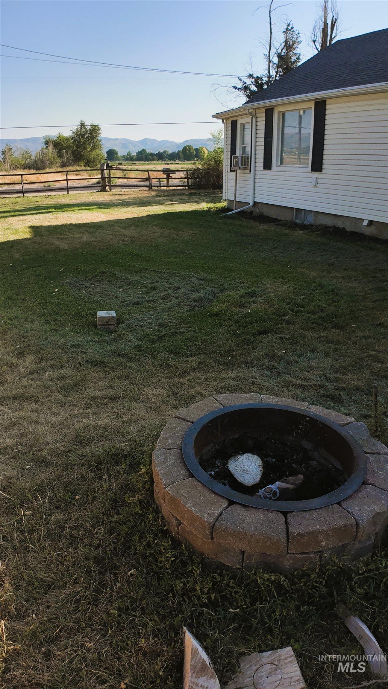 View of yard featuring an outdoor fire pit, a mountain view, and a view of rural / pastoral area