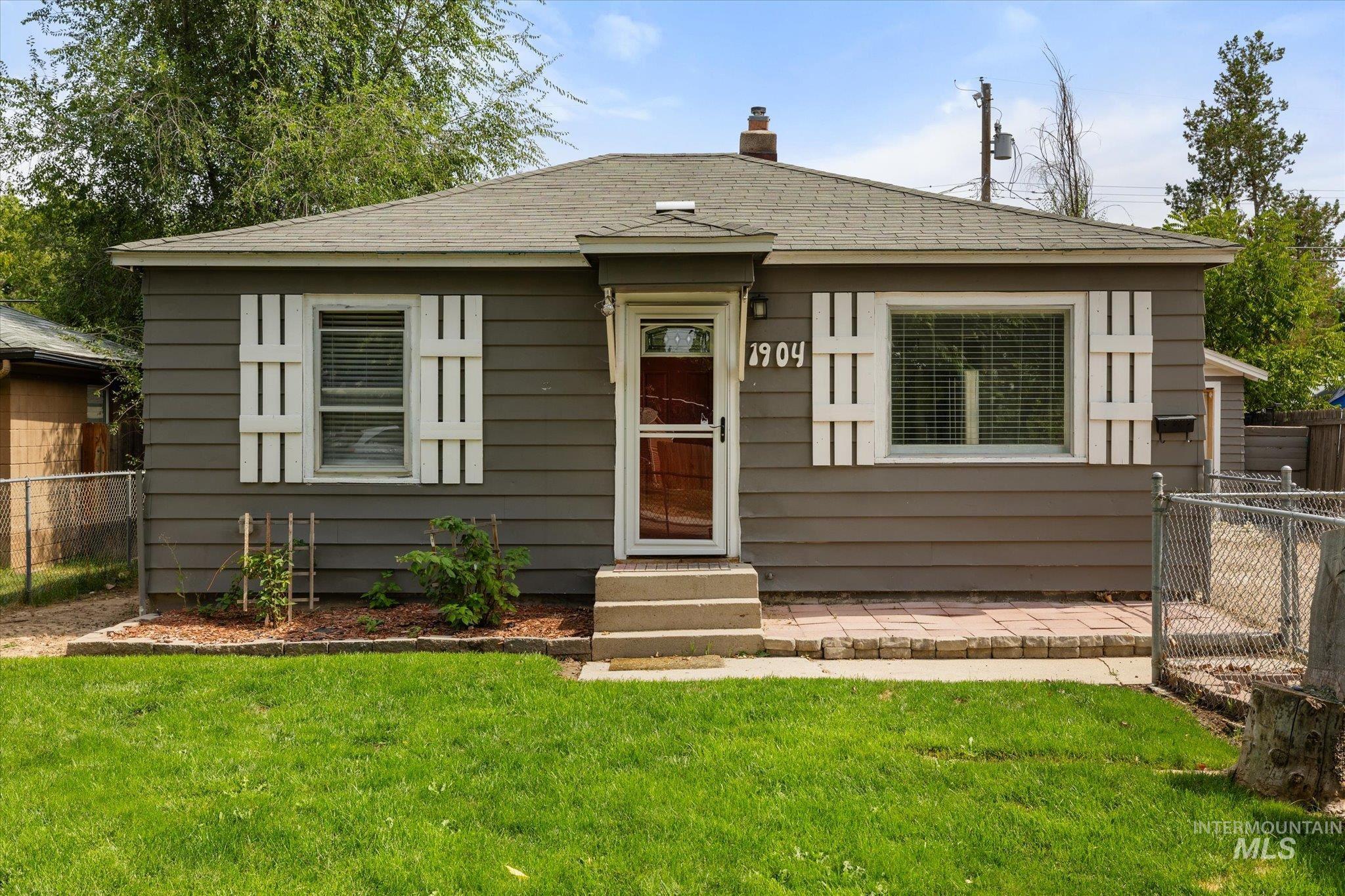 Bungalow-style home featuring roof with shingles, a chimney, and entry steps