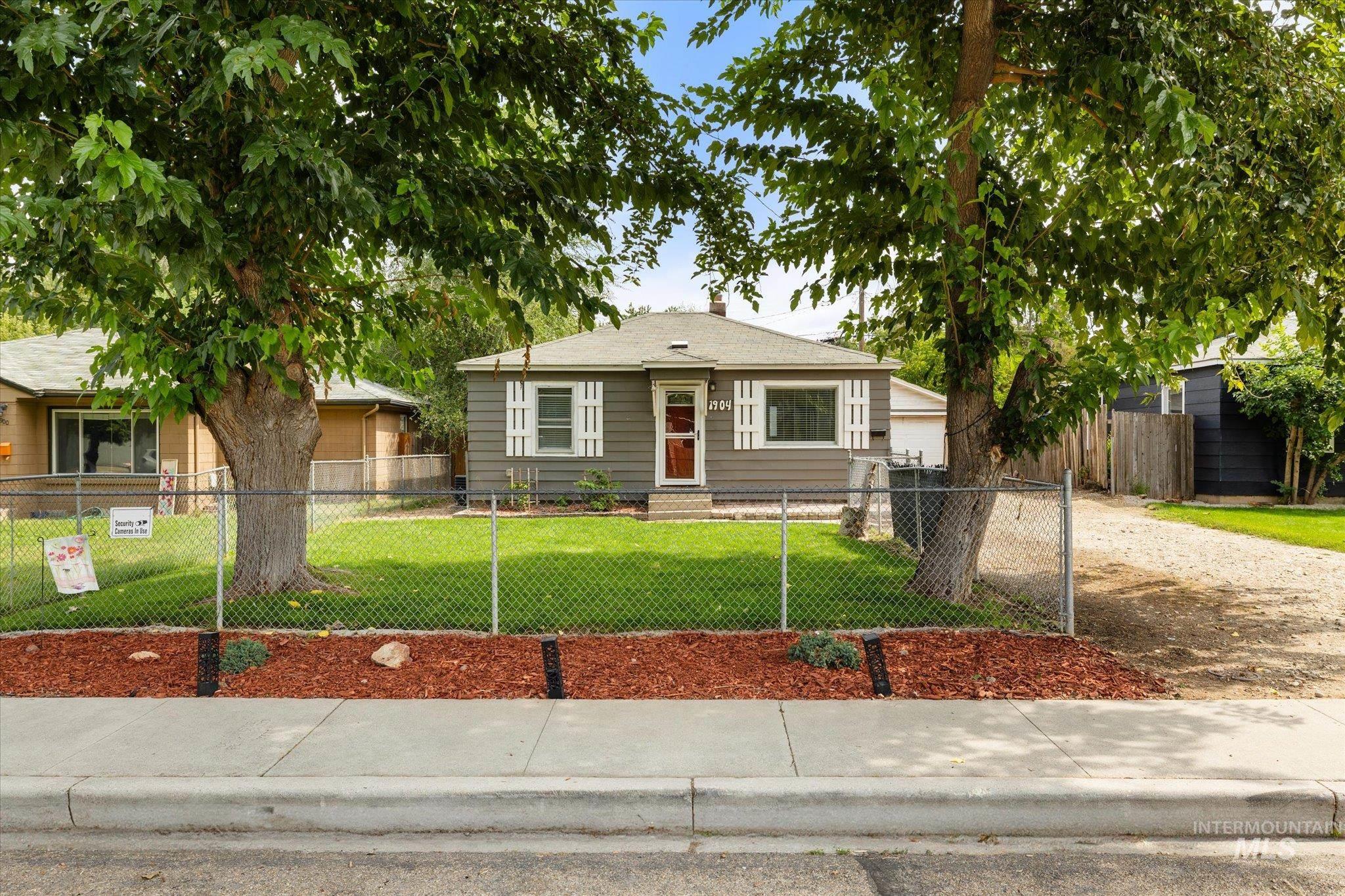Bungalow featuring a fenced front yard and a chimney