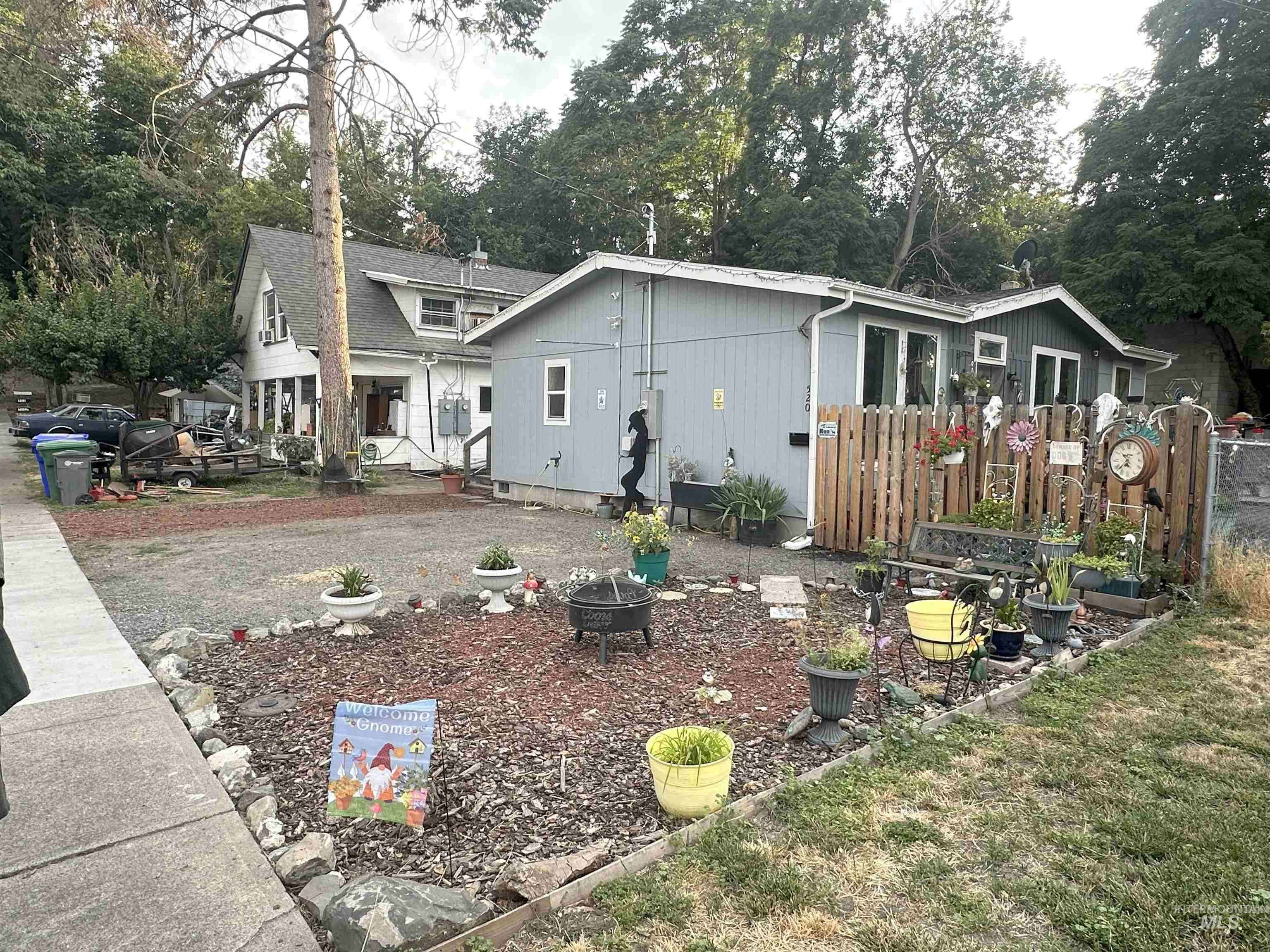 Back of house featuring view of scattered trees and a fire pit