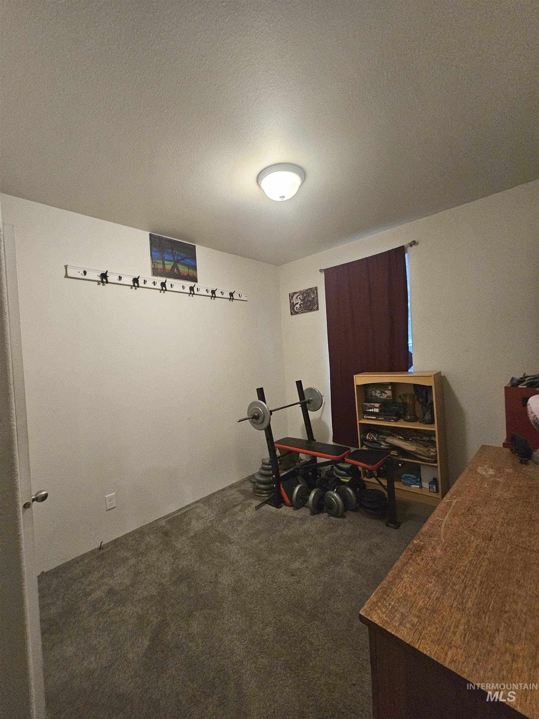 Office featuring a textured ceiling and dark colored carpet