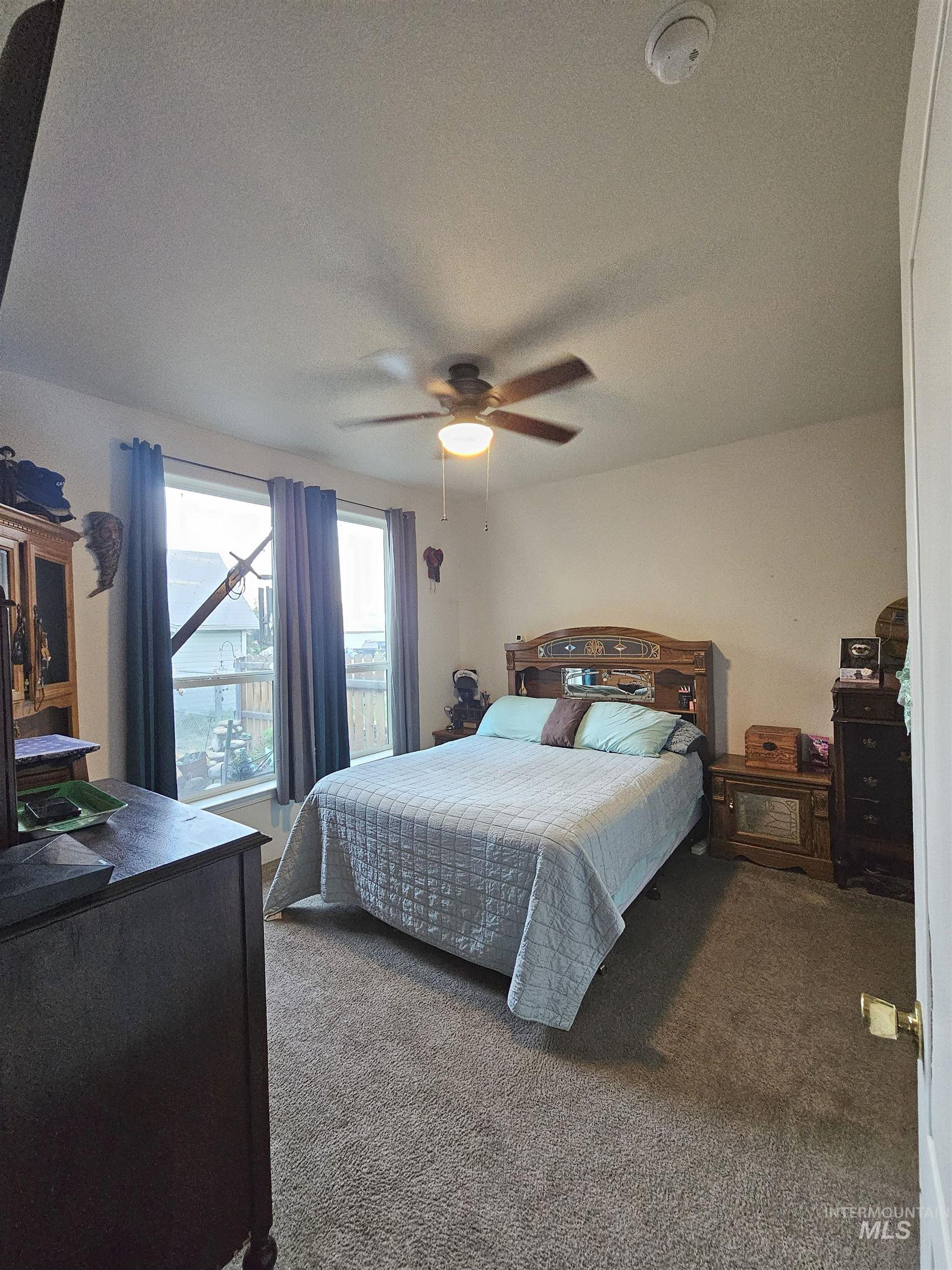Bedroom featuring carpet flooring, a textured ceiling, and ceiling fan