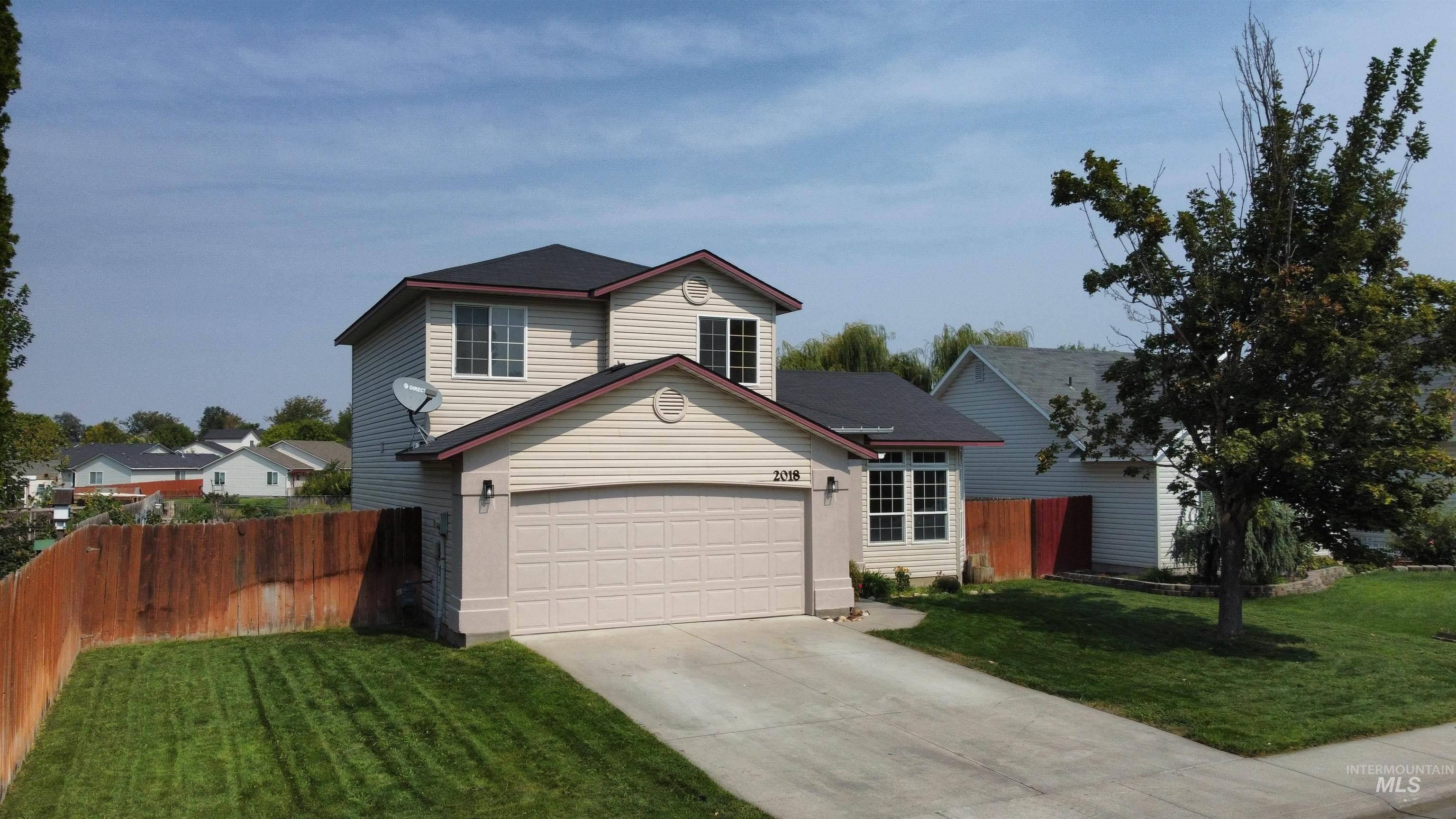 Traditional-style house featuring a garage and concrete driveway