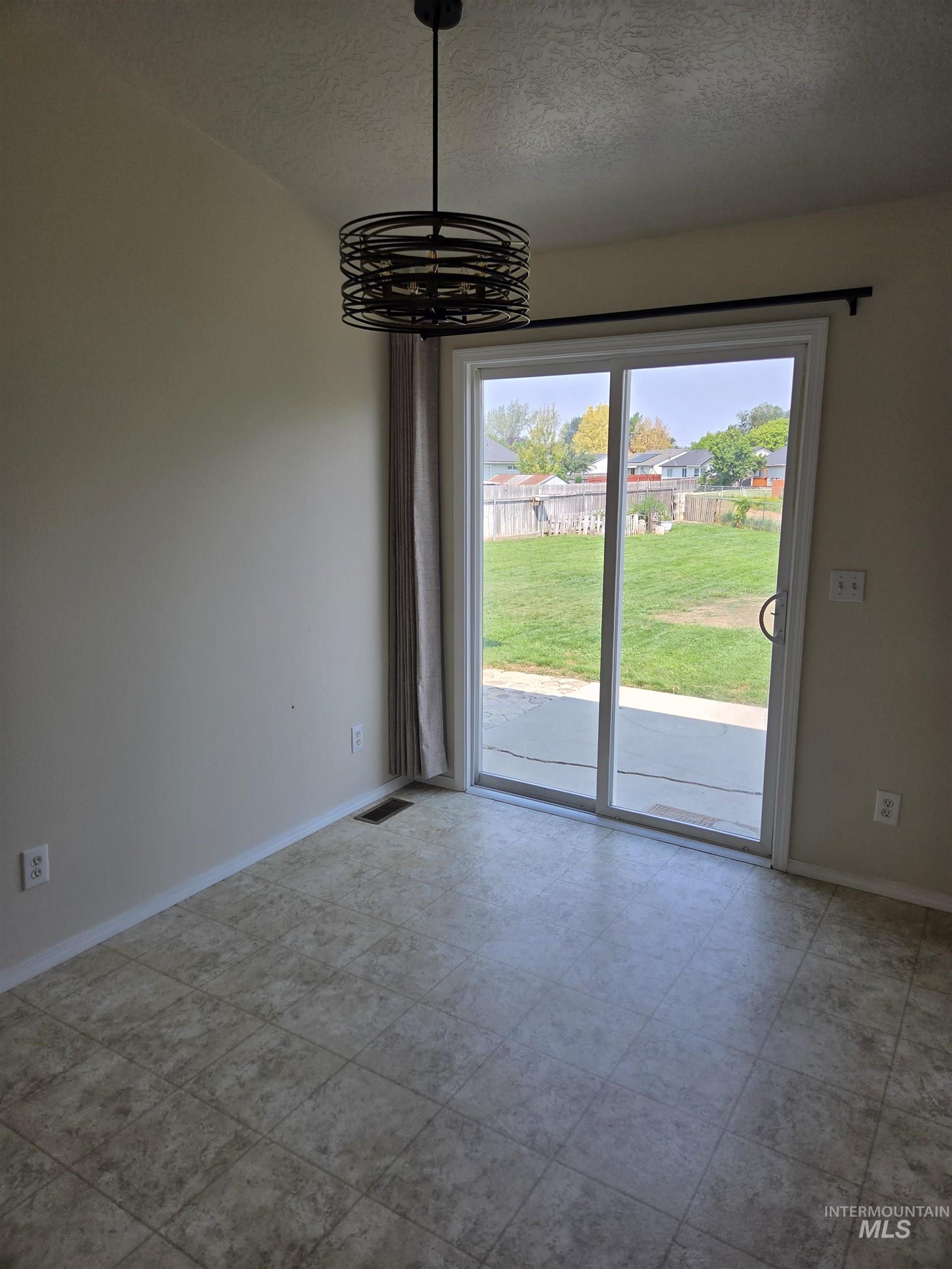 Unfurnished dining area with a textured ceiling and baseboards