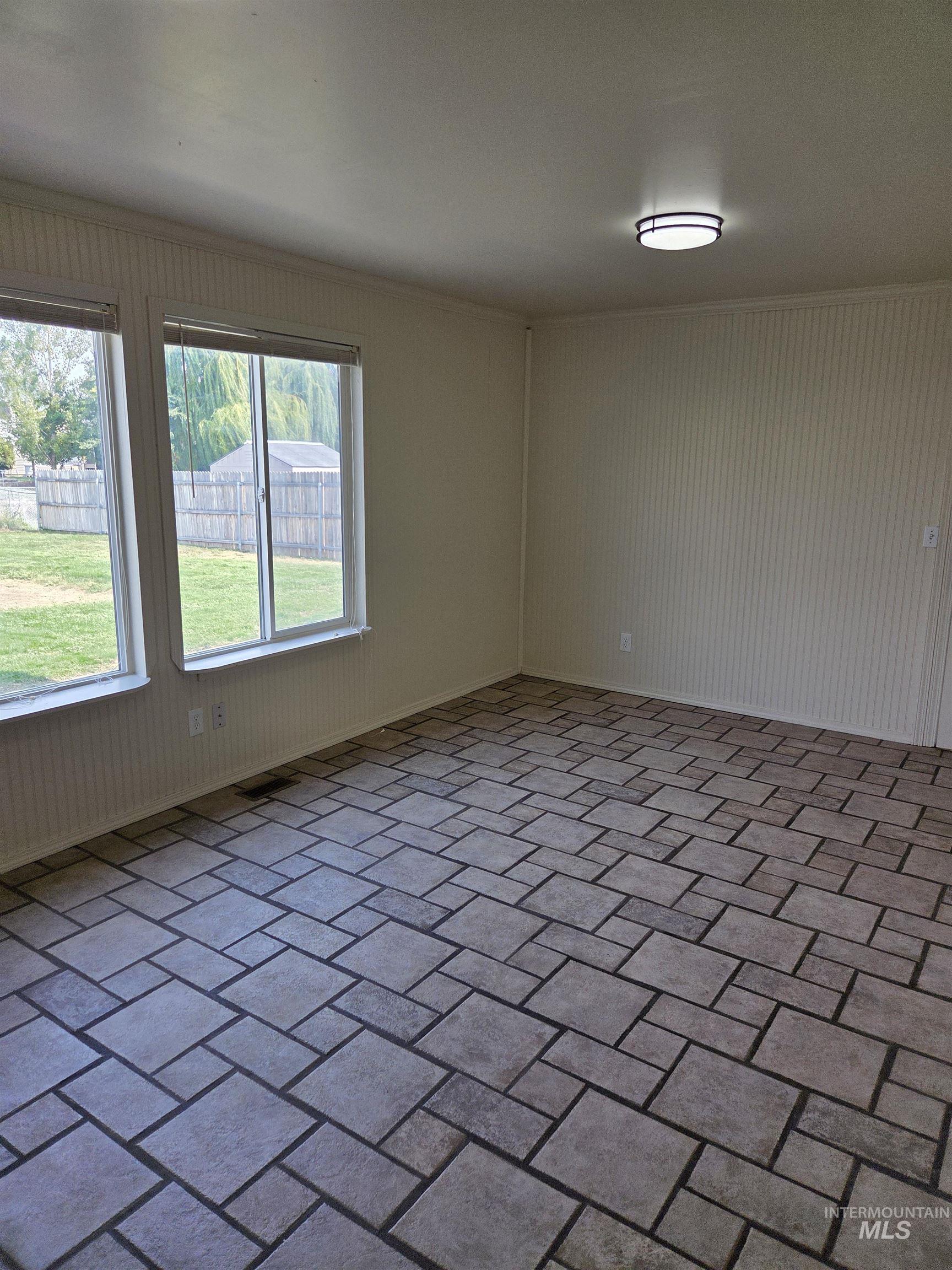 Empty room with brick floors and crown molding