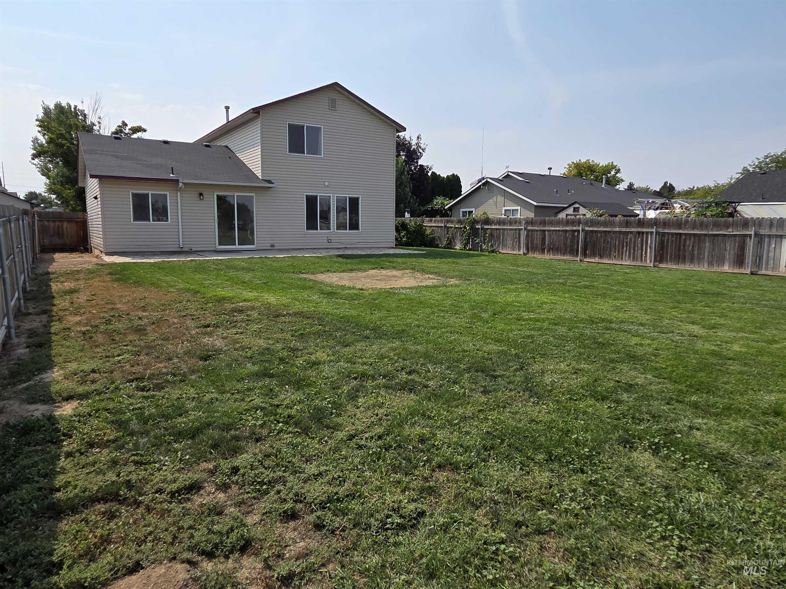 Back of property featuring a fenced backyard and a patio